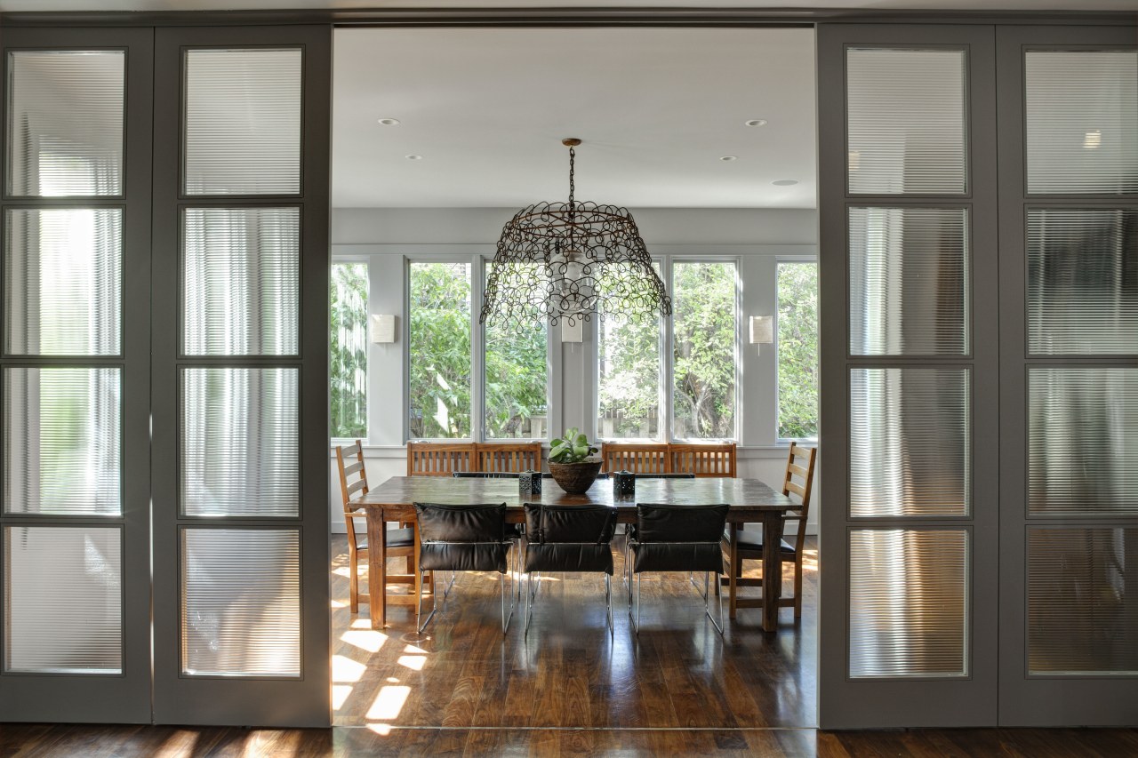 Sliding glass doors with reeded glass separate the dining room, door, furniture, home, house, interior design, table, window, gray, black