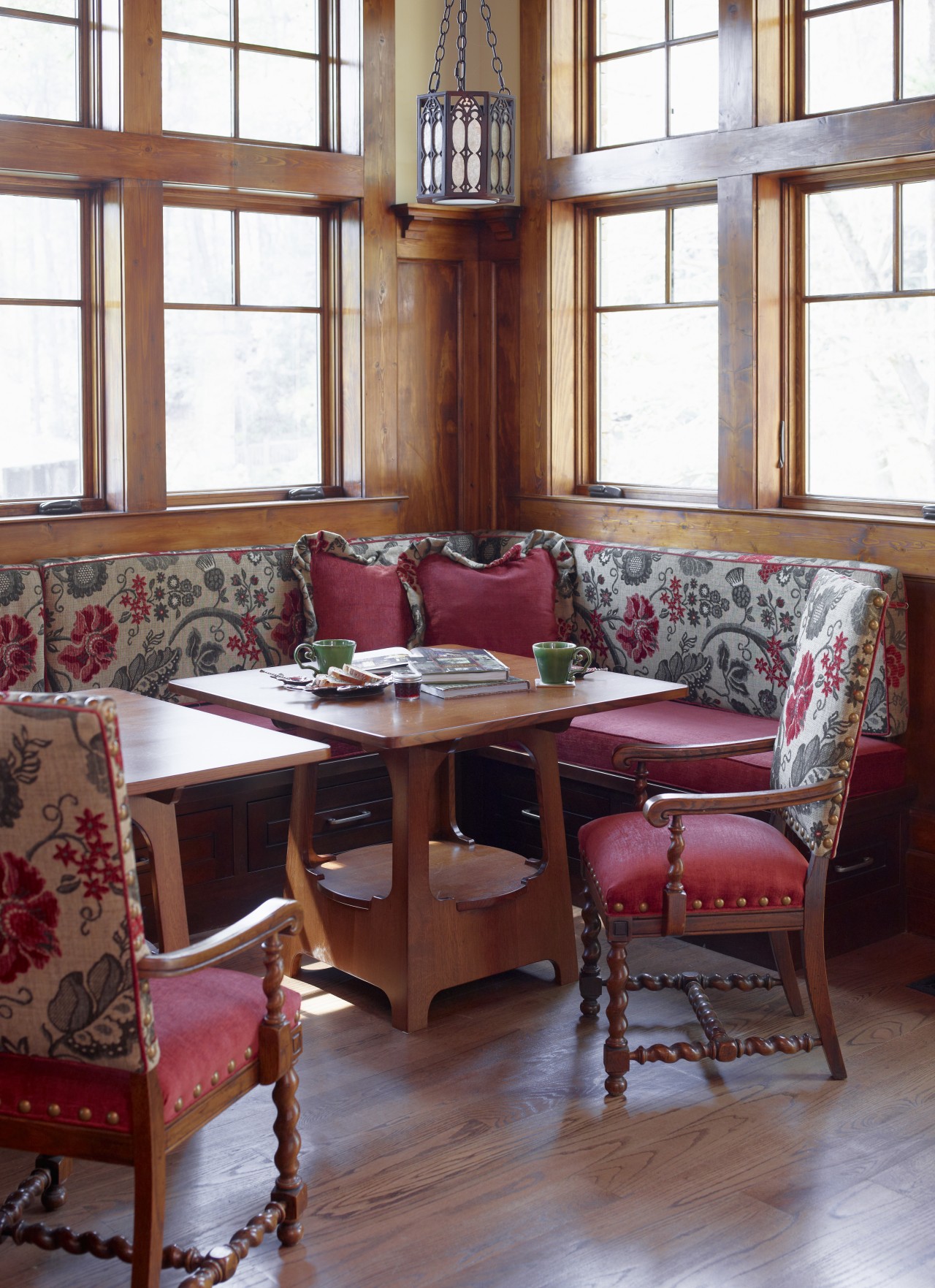 This seating nook creates an intimate dining space chair, dining room, flooring, furniture, home, house, interior design, living room, room, table, window, wood, red, white