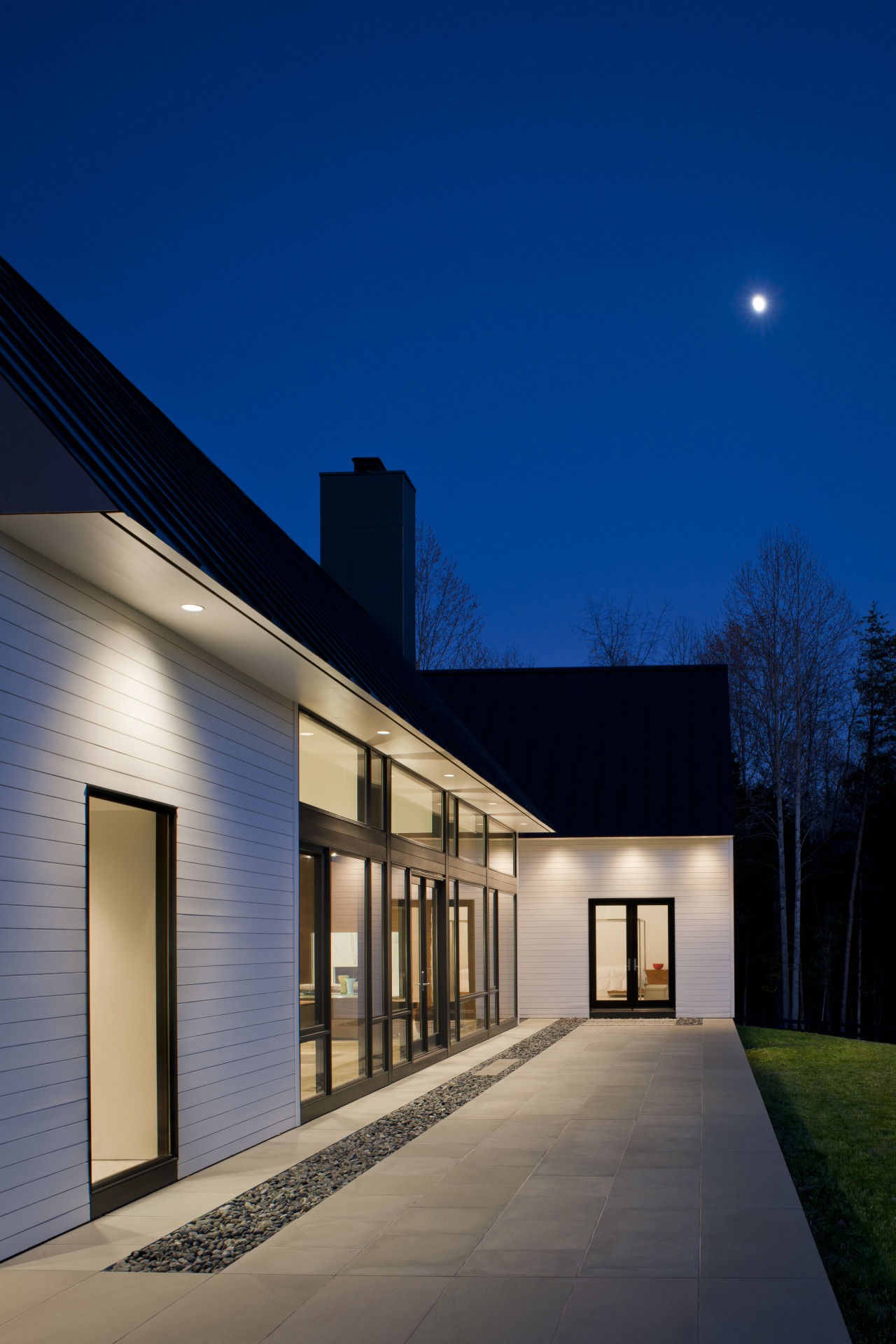 Clapboard siding and a metal roof place this architecture, building, daylighting, estate, evening, facade, home, house, lighting, property, real estate, residential area, sky, sunlight, window, blue