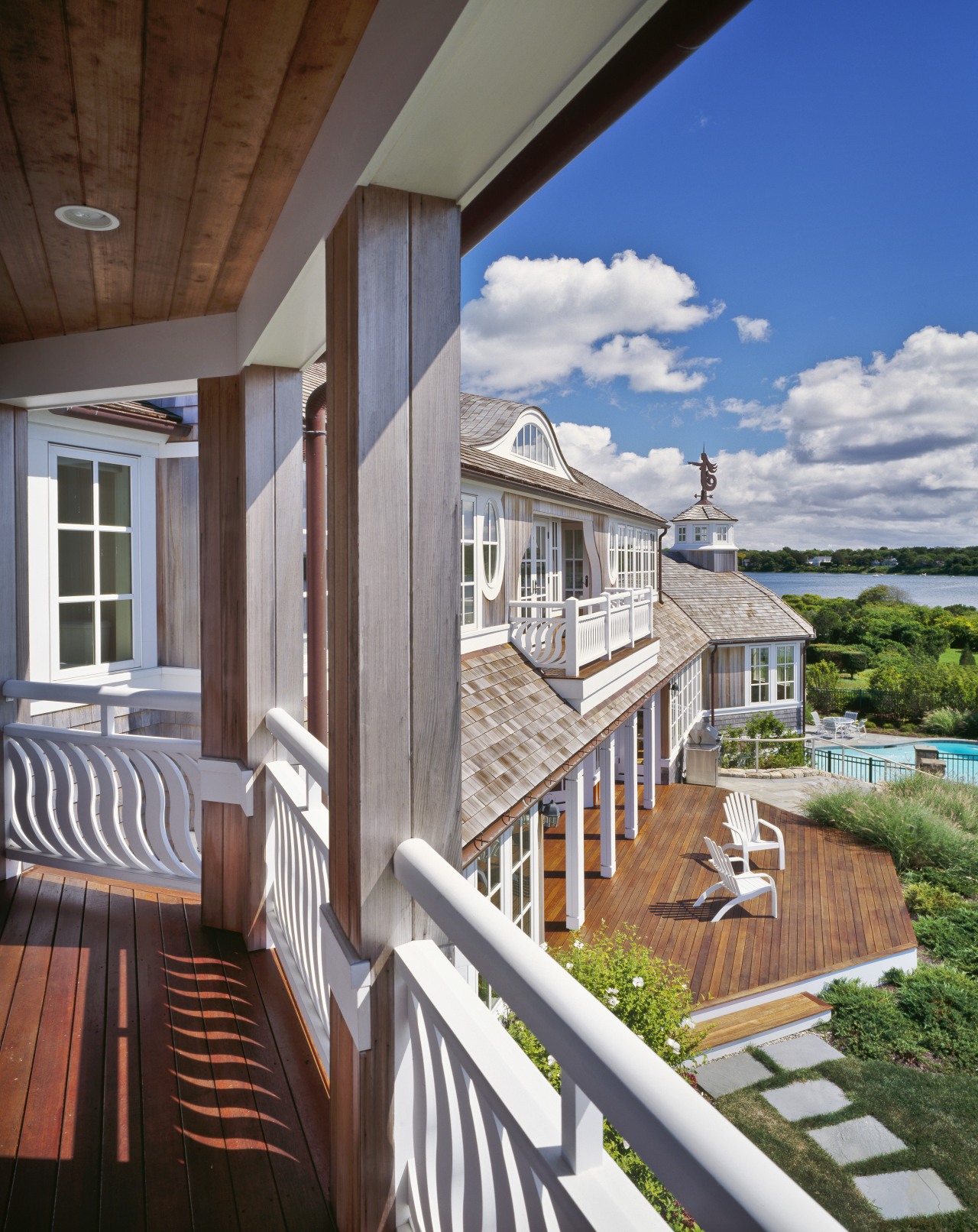 The generous decking, French doors and uniform white apartment, balcony, cottage, deck, estate, home, house, outdoor structure, porch, property, real estate, residential area, siding, window, wood, gray