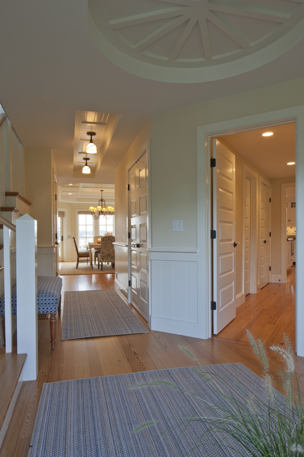 In this Cape Cod house, corridors lead off apartment, architecture, ceiling, daylighting, door, estate, floor, flooring, hardwood, home, house, interior design, laminate flooring, living room, lobby, real estate, room, wall, window, wood, wood flooring, gray, brown