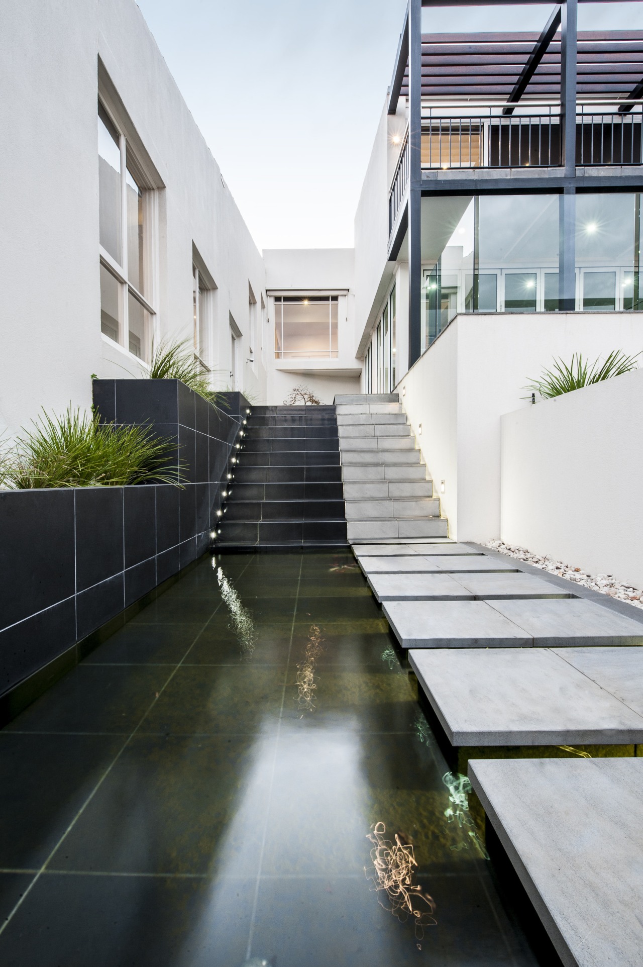 A water feature, lined with dark tiles, provides apartment, architecture, building, condominium, daylighting, estate, facade, home, house, property, real estate, reflection, residential area, white