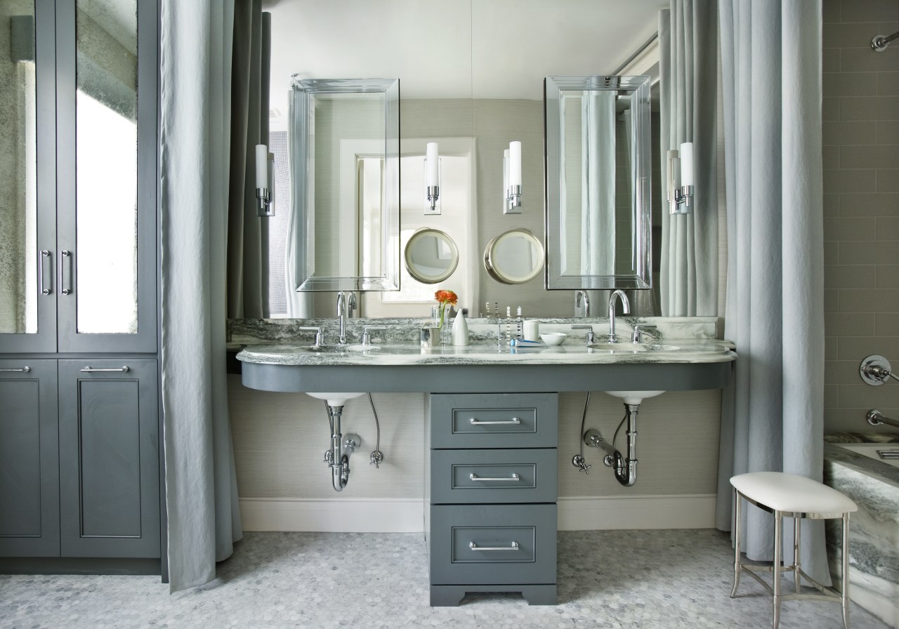 This remodeled bathroom incorporates a reflective wall of bathroom, bathroom accessory, bathroom cabinet, home, interior design, room, sink, gray