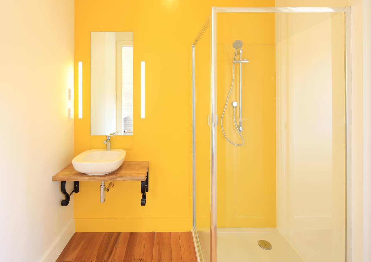 Oversized cavity sliders and lively yellow wall paint bathroom, floor, interior design, plumbing fixture, product design, room, wall, yellow, orange