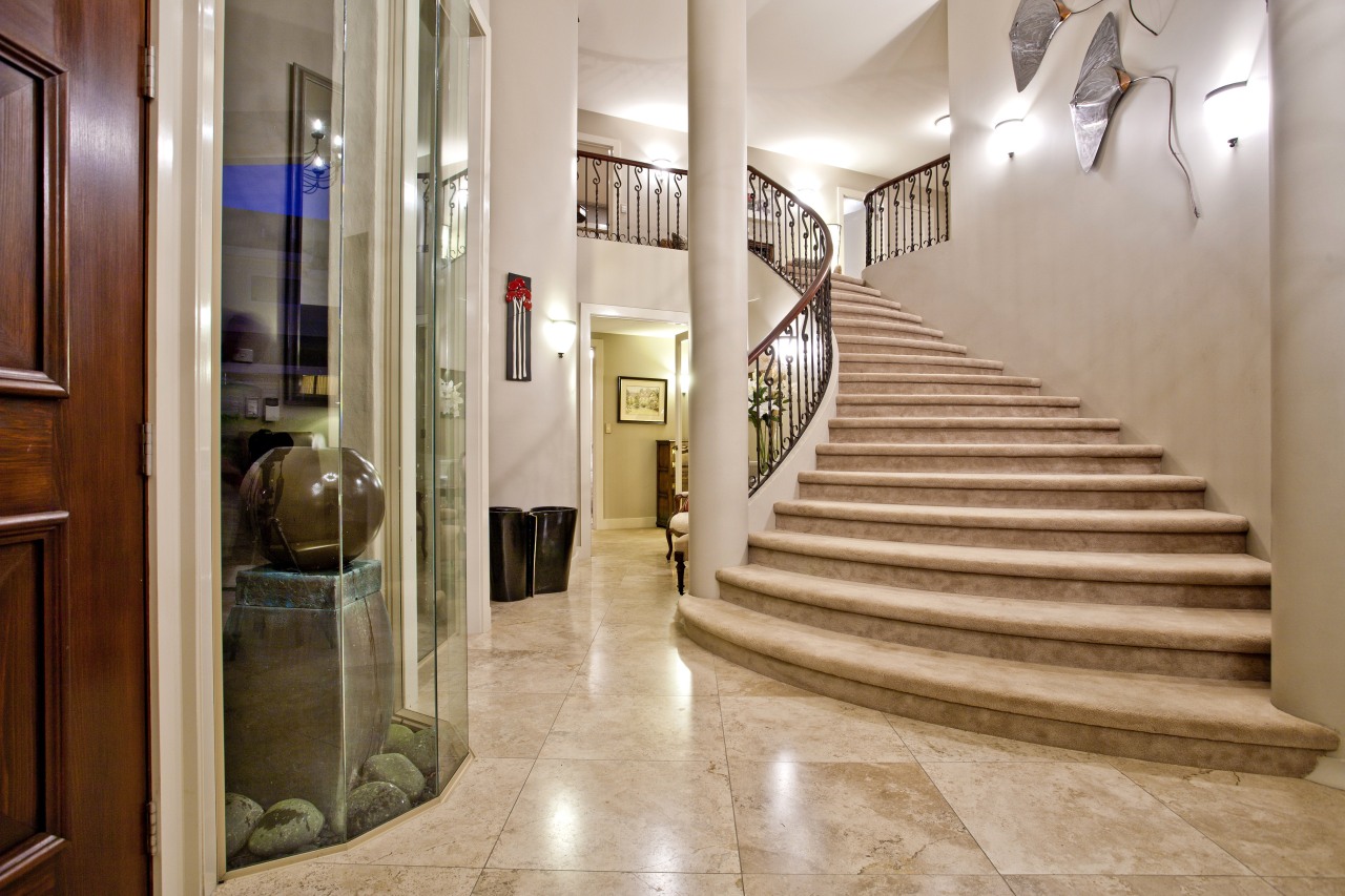 Grand, sweeping marble staircase and floor greets the apartment, estate, floor, flooring, home, interior design, lobby, property, real estate, stairs, gray, orange, brown