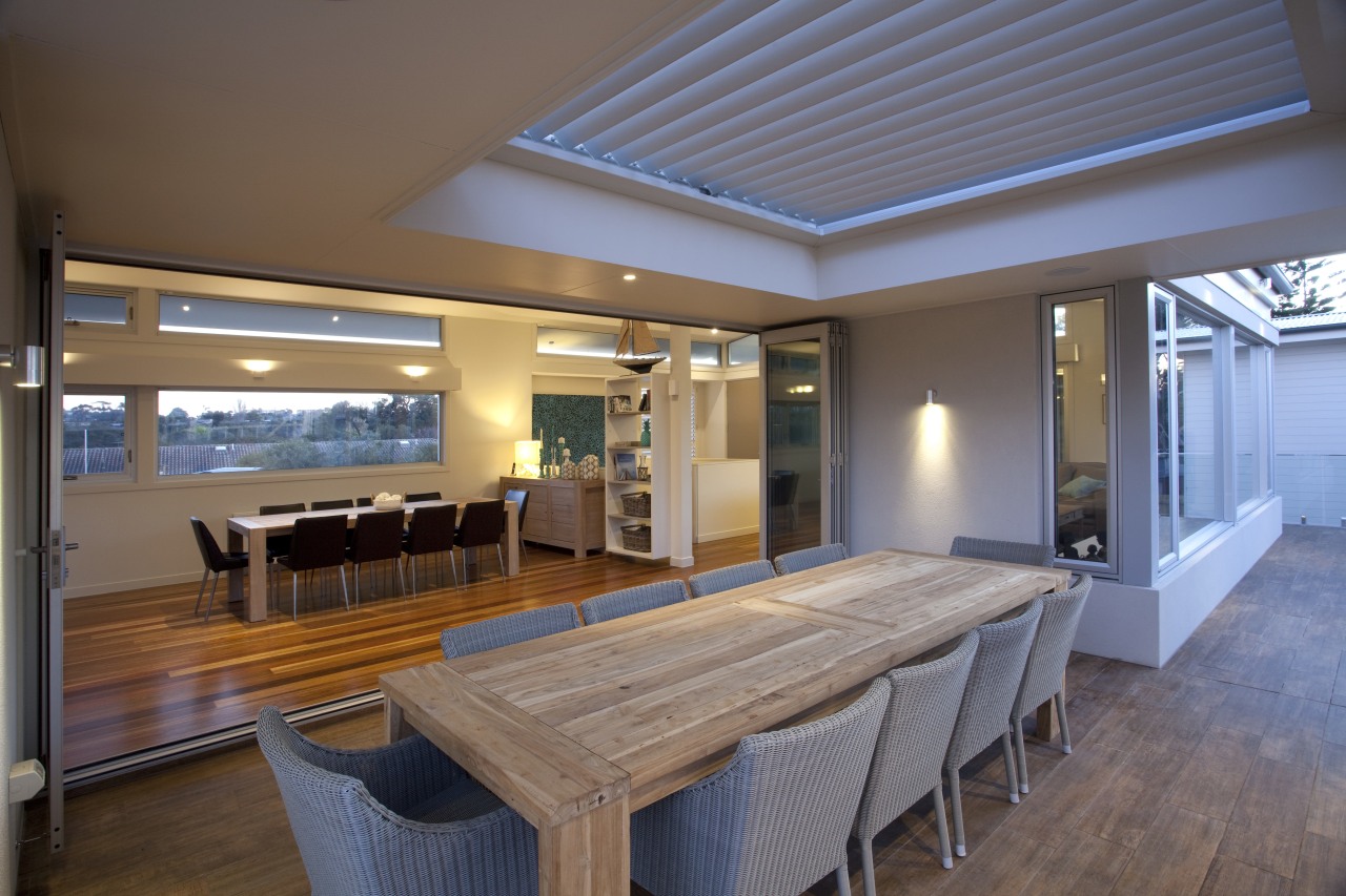 Beautiful alfresco covered by operable louvre to maintain ceiling, daylighting, dining room, estate, floor, flooring, house, interior design, property, real estate, table, window, wood, gray, brown