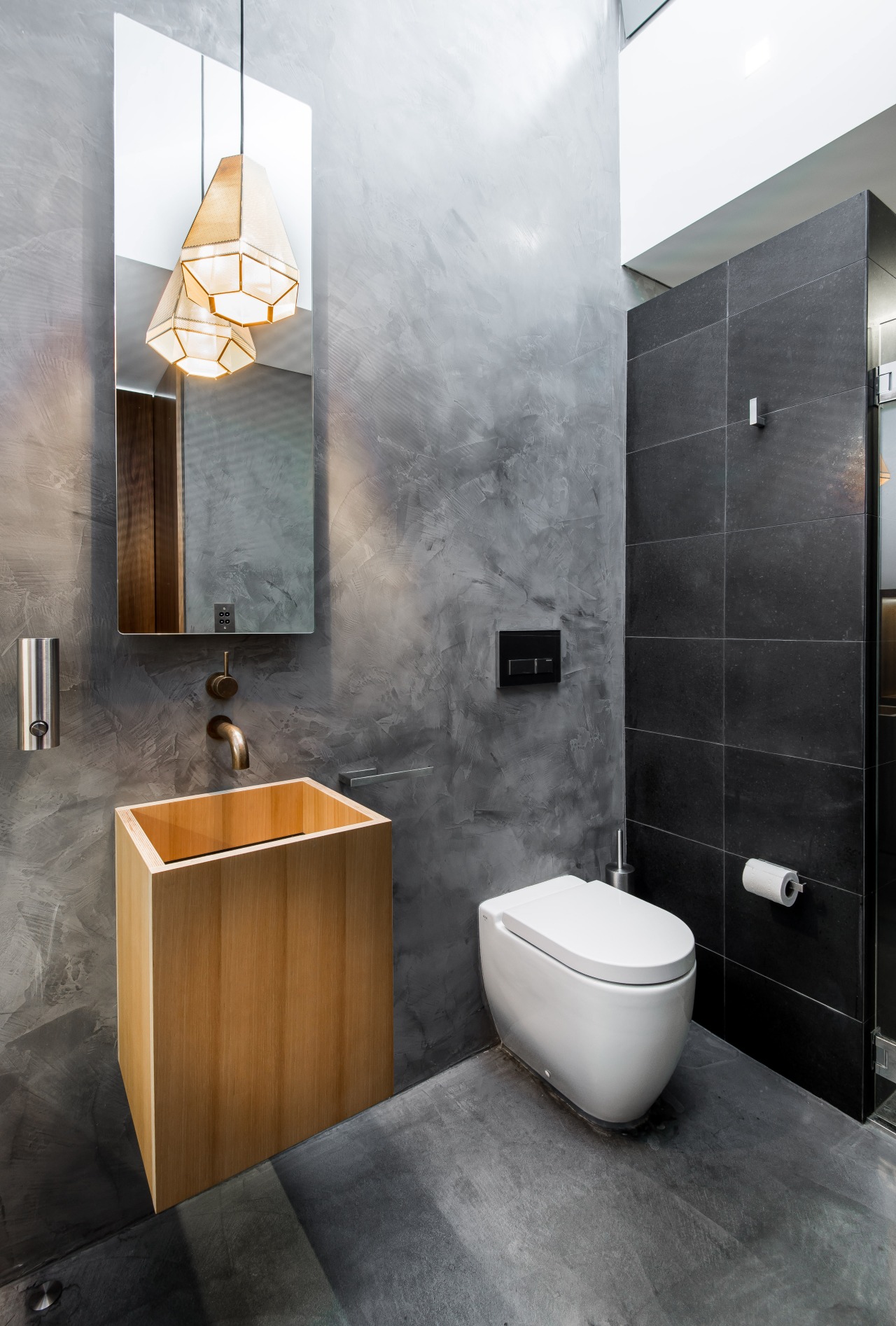 This discreet bathroom by designer Joe Chindarsi is bathroom, bathroom accessory, bathroom cabinet, ceramic, floor, interior design, plumbing fixture, product design, room, sink, tap, tile, wall, gray, black, white