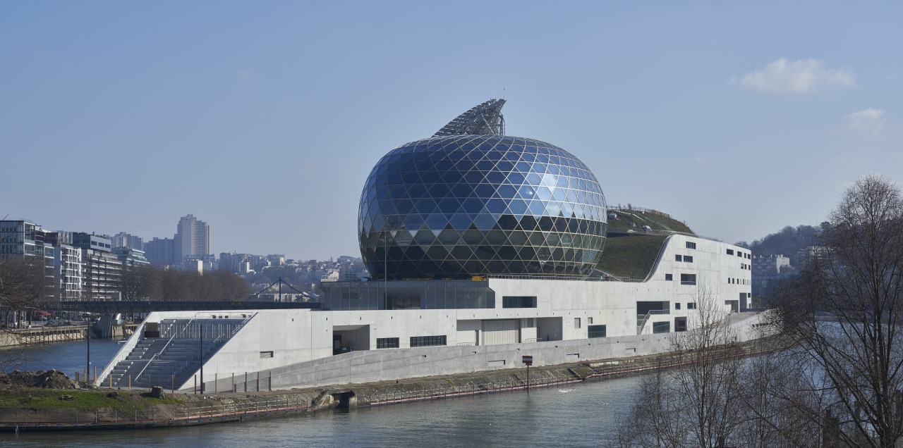 The glass and timber ovoid shape of the architecture, building, city, daytime, reflection, river, sky, water, teal, gray