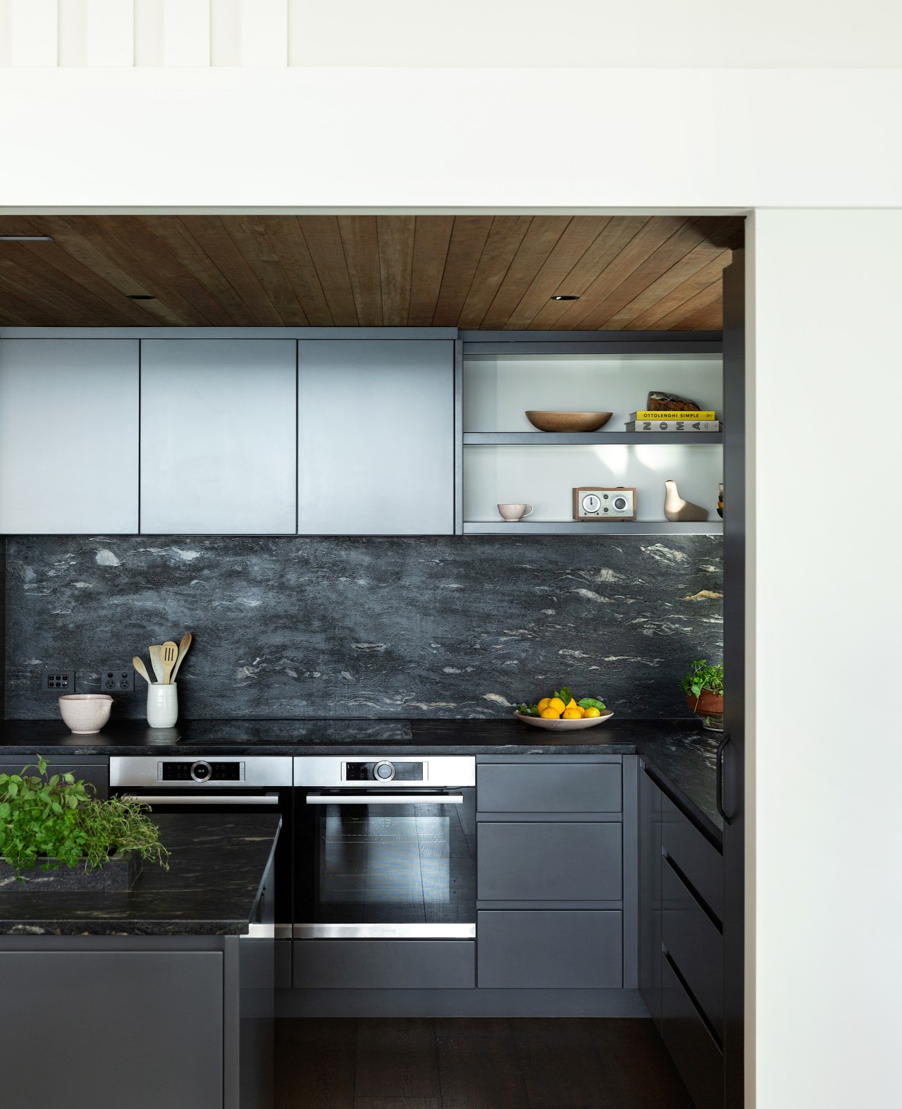 The stone-look splashback echoes the tones of the 