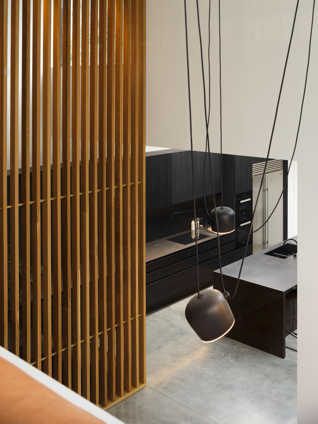 View of kitchen from stairs with pendants in 