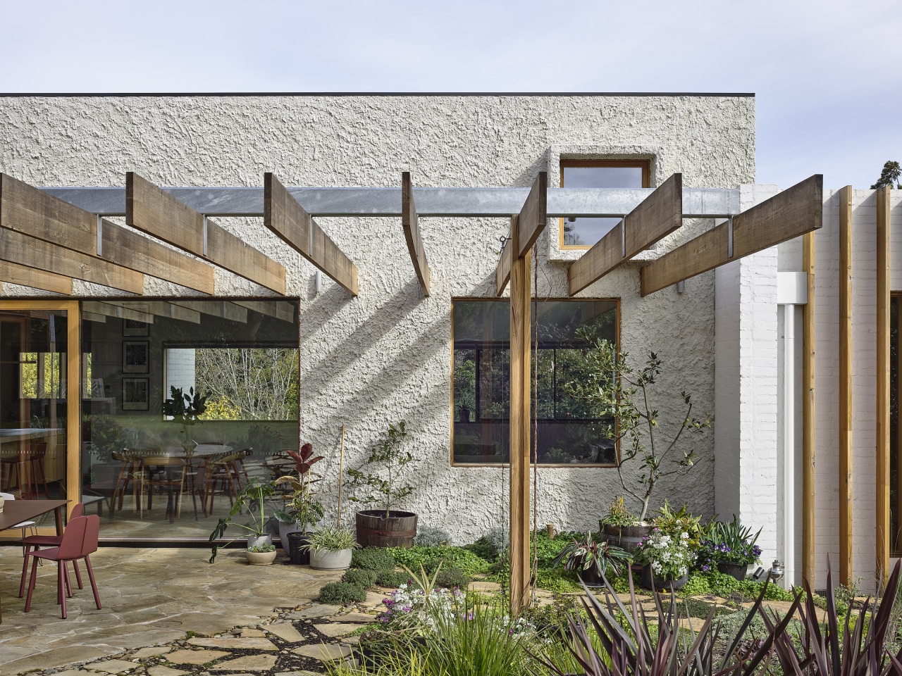 Victorian Ash timber beams of the pergola continue 