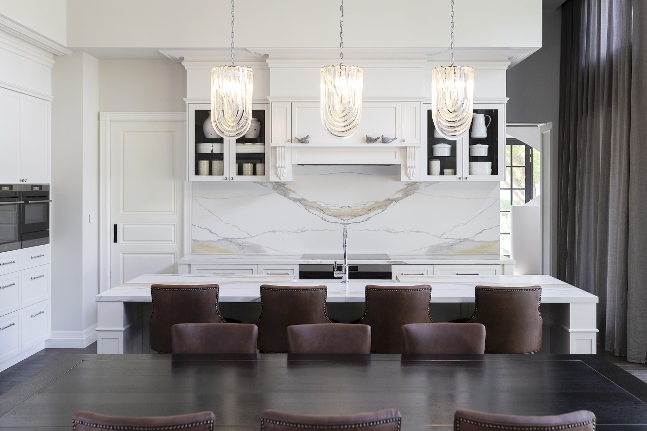 Panelled kitchen cabinetry and a marble splashback add 