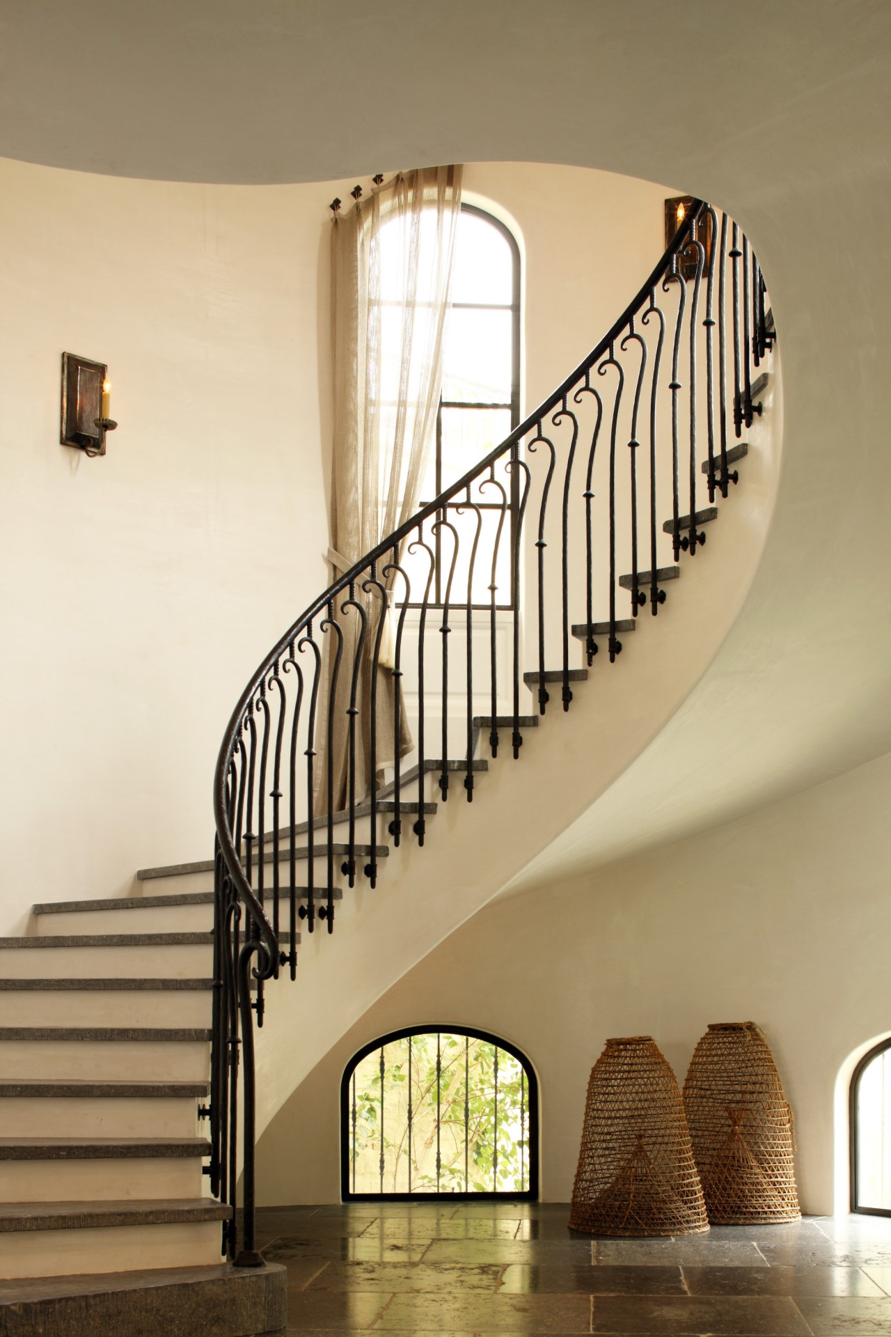 This graceful staircase, lined with bespoke wrought iron 