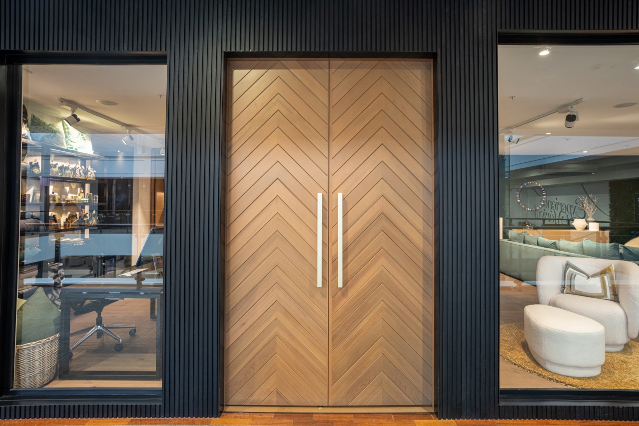 The grand herringbone entry doors feature brass handles 