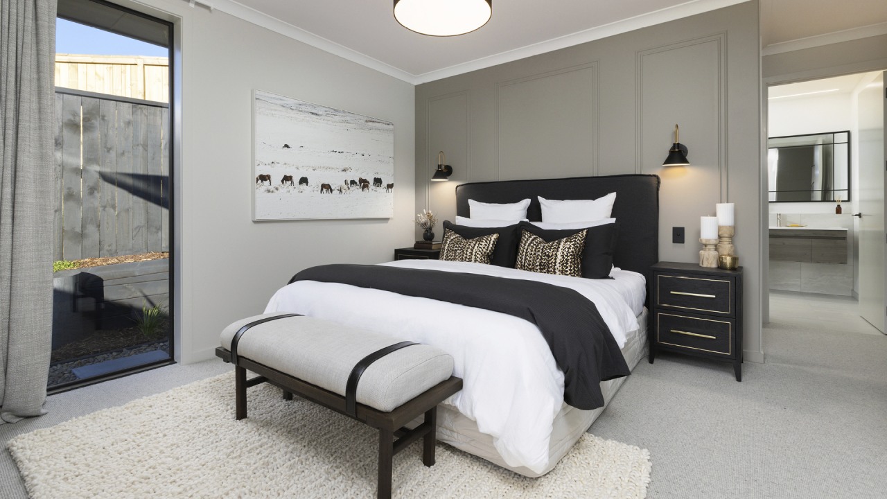 A feature panelled wall backs the bed in 