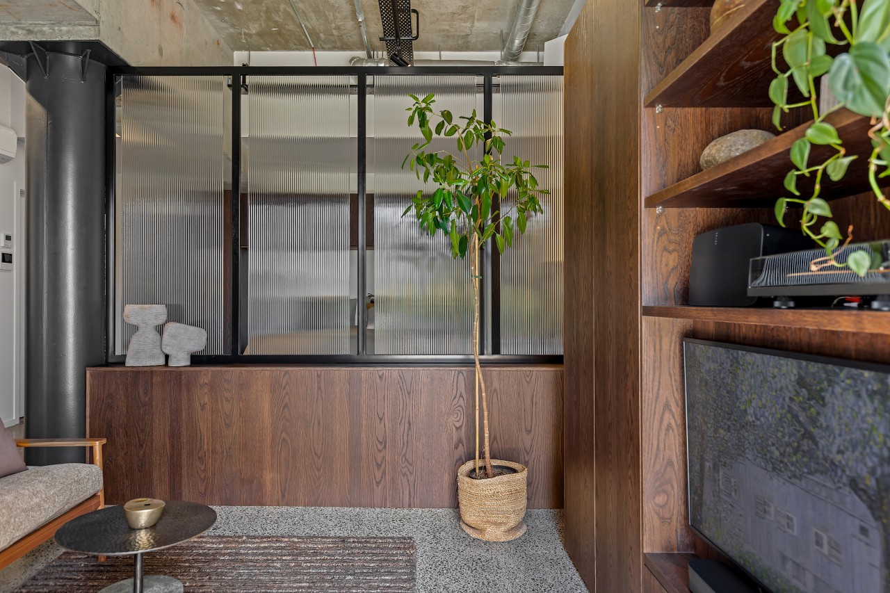 The interplay between warm timber, textured glass, and 
