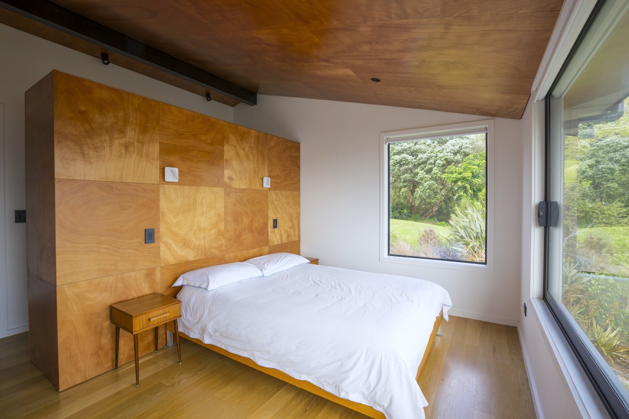 South-facing master bedroom complete with rich-toned timber headboard. 