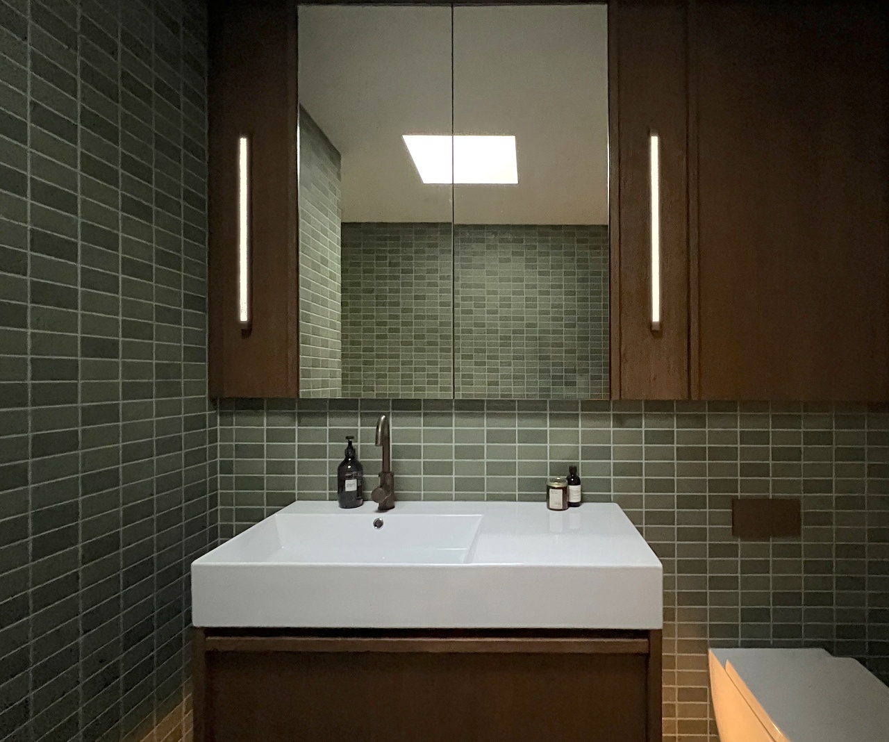 A mirror-fronted cabinet adds to the sense of 
