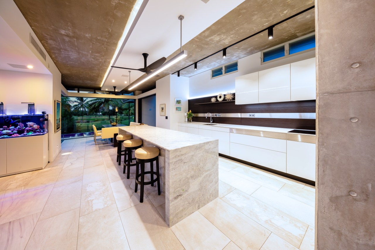 This marble island has a waterfall countertop with countertop, floor, flooring, interior design, kitchen, real estate, gray