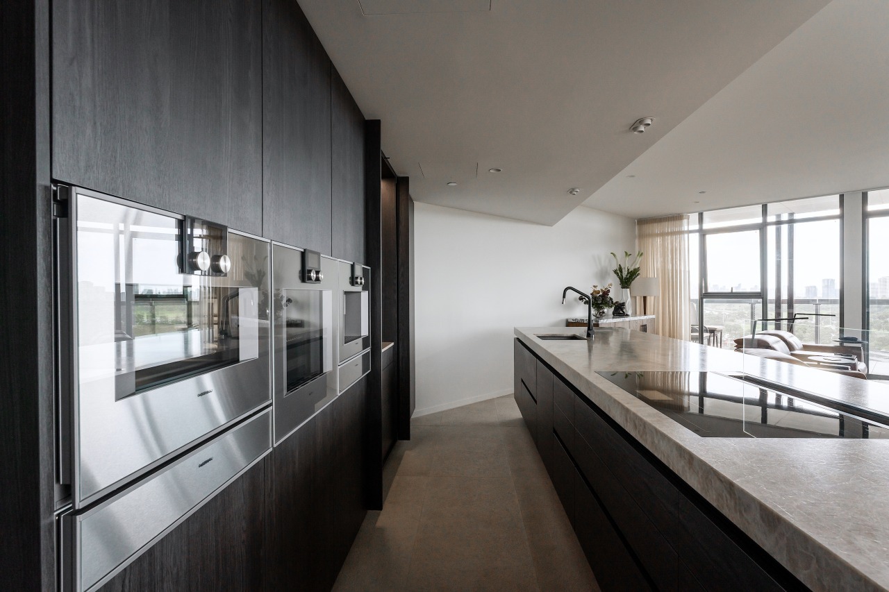The kitchen embraces a completely handleless concept, featuring 