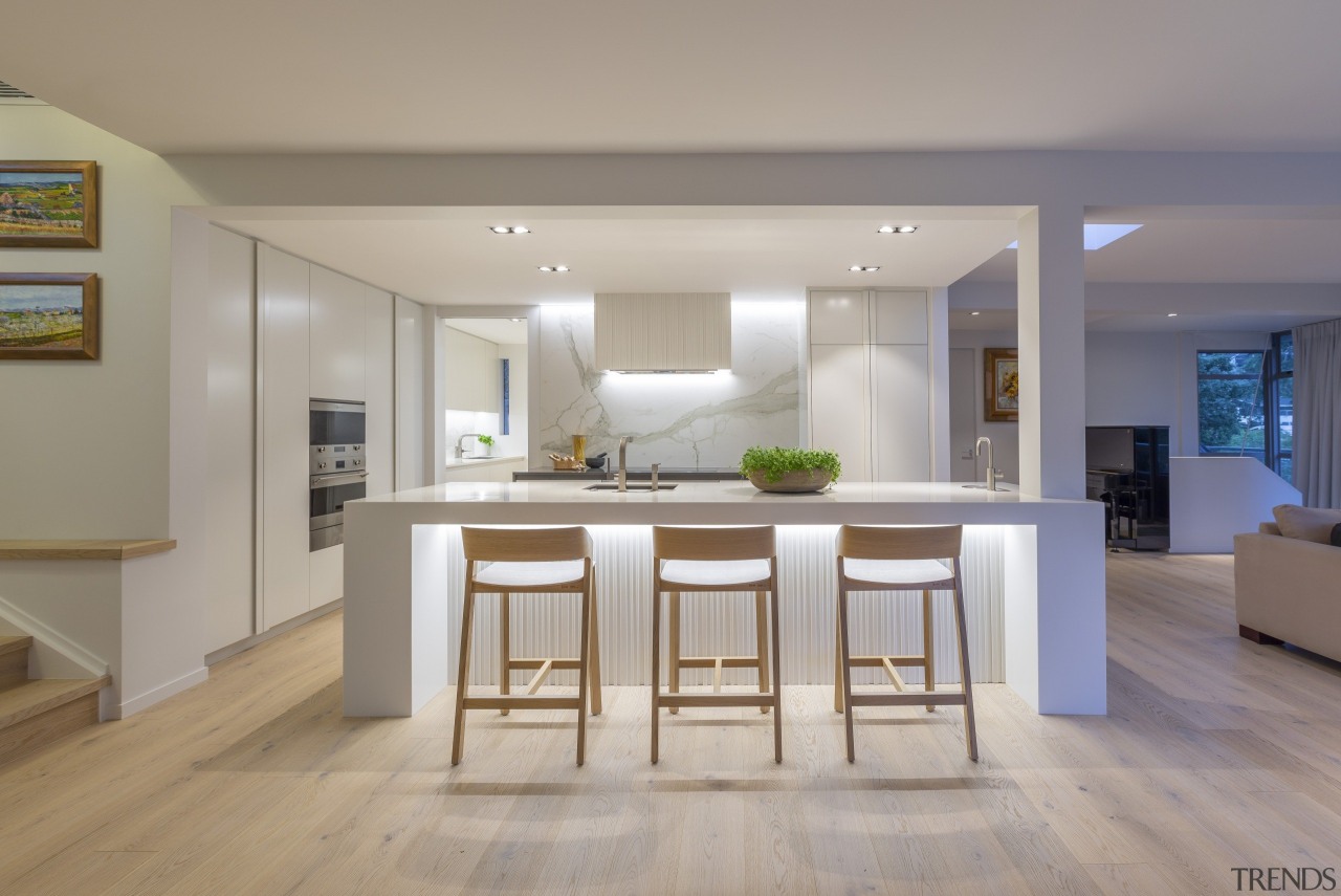 Crisp, white, Scandinavian-look kitchen with brushed oak flooring 