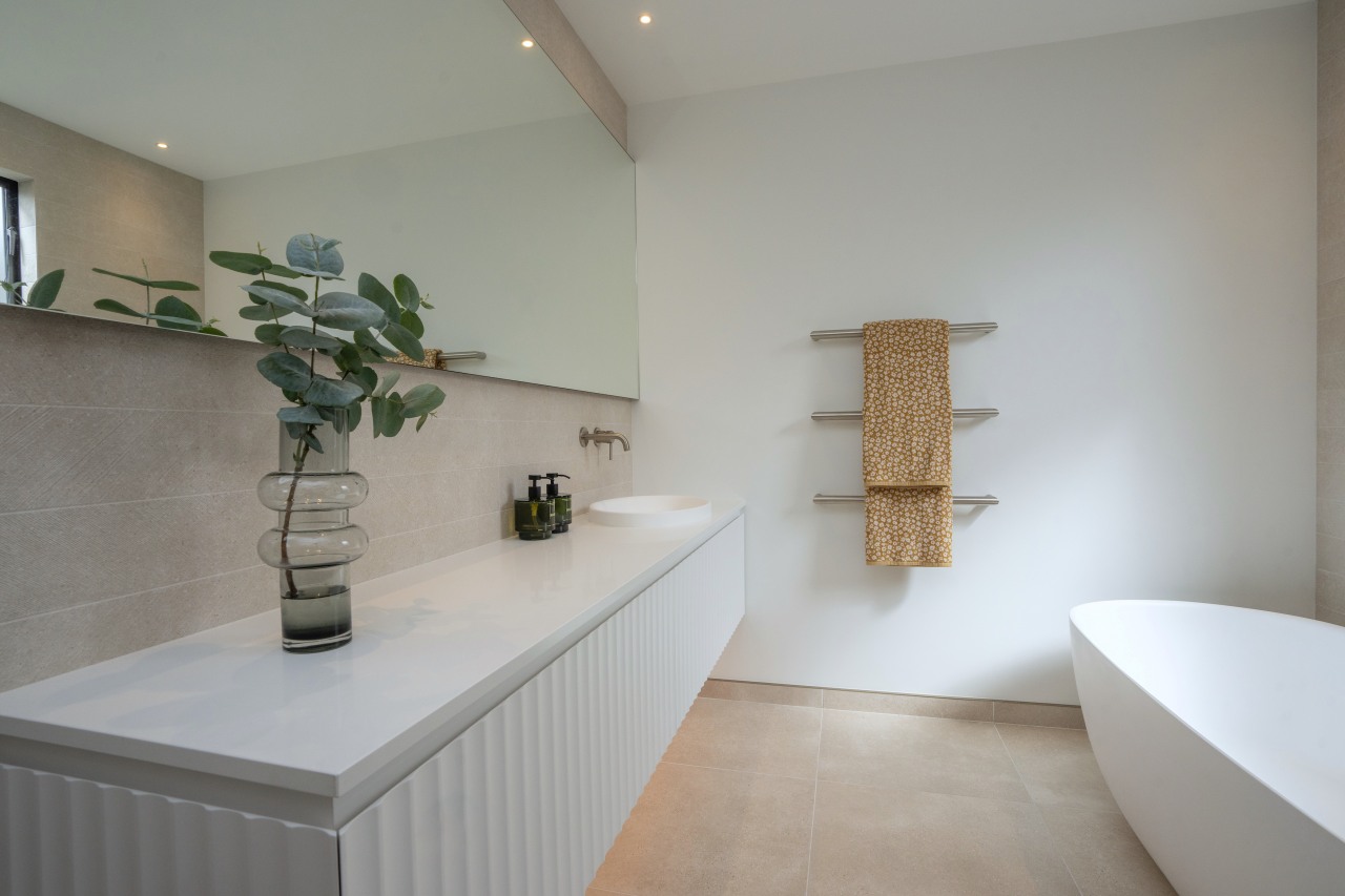 Bespoke mirrors enhance brightness in the renovated bathrooms. 