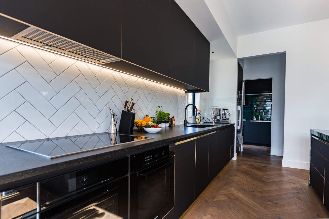 An iridescent wall tile features in the kitchen's 