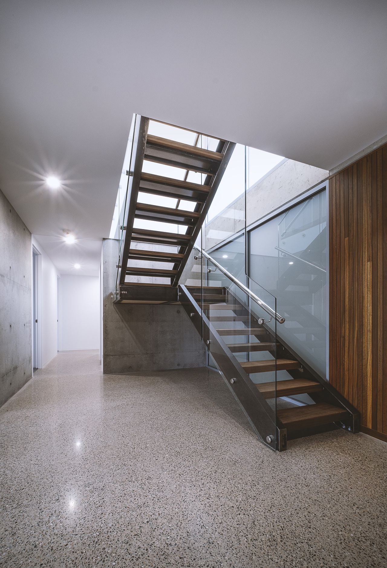 A translucent glass wall sits beyond the stairs 