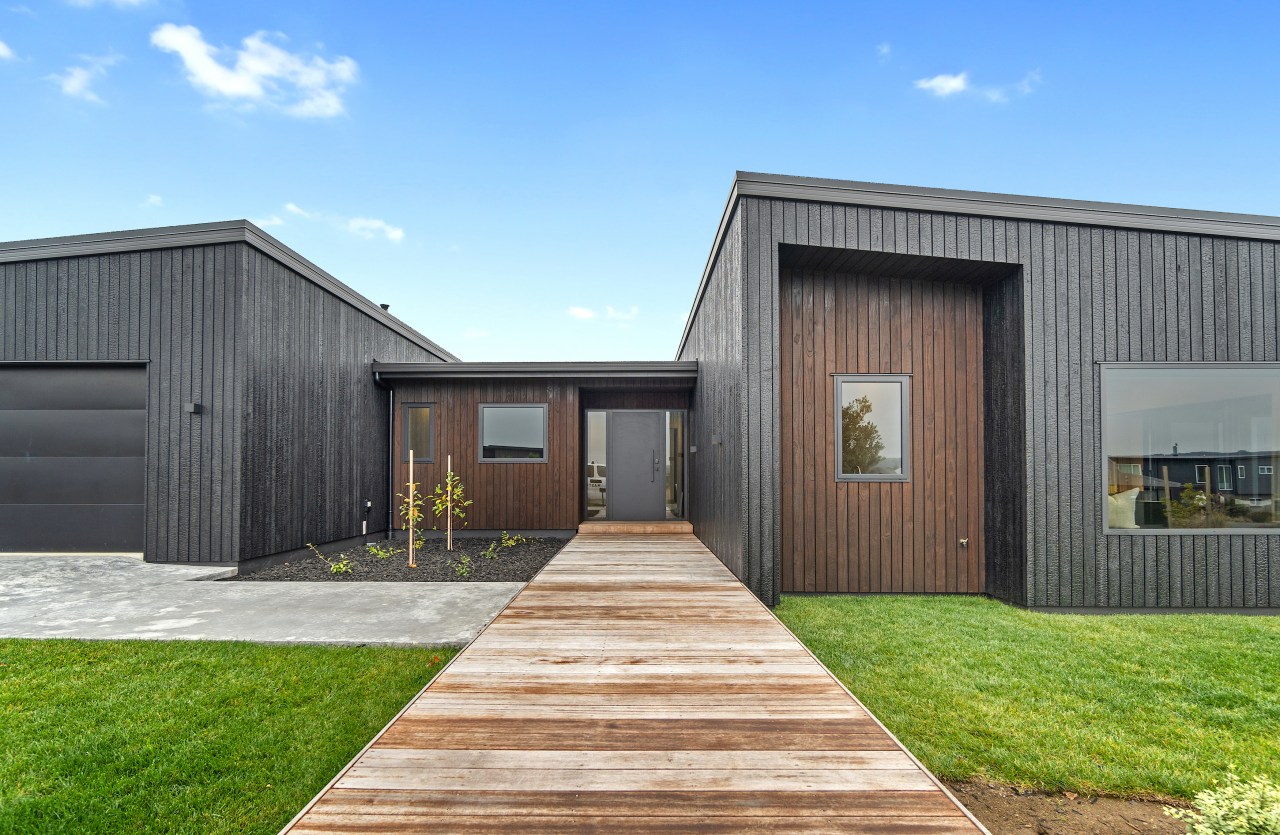 A kwila boardwalk-style path leads to the front 