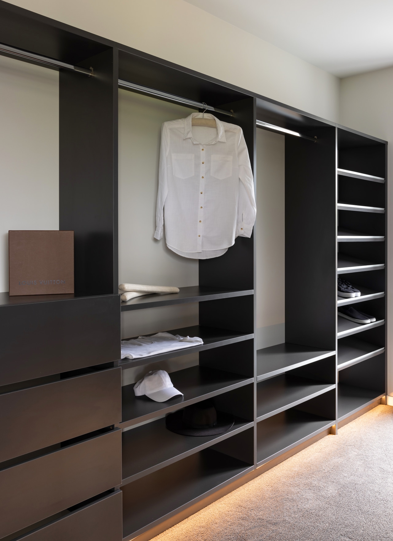 The walk-in robe features custom wood cabinetry with 