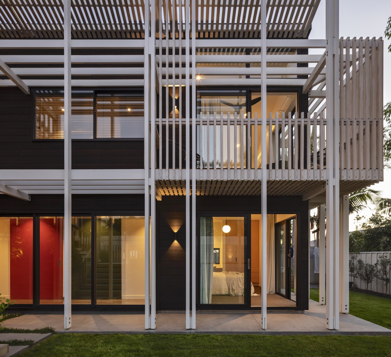 Dark stained timber weatherboards are contrasted with white-washed 