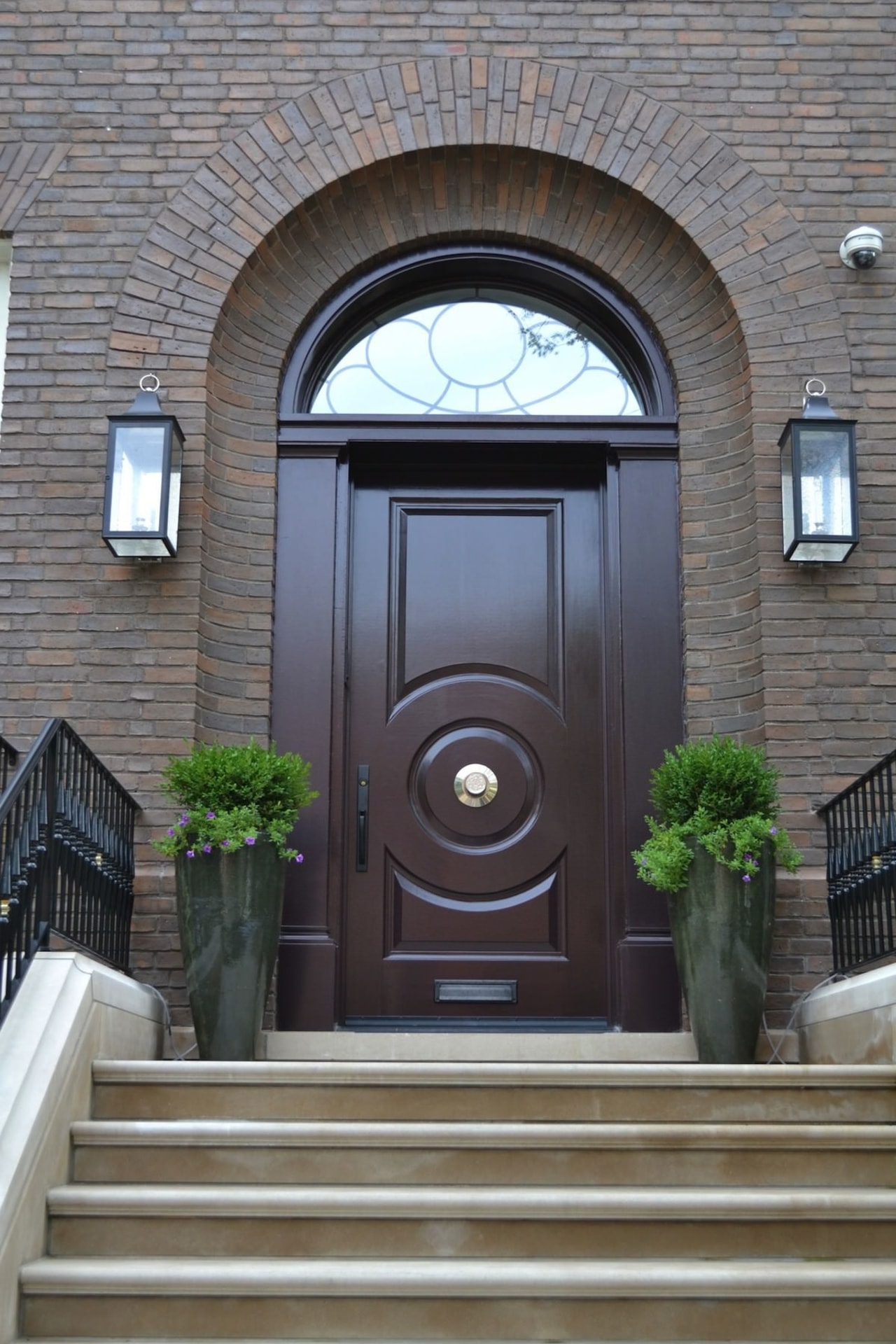 The front entrance harkens back to the home's arch, door, facade, home, window, gray, black