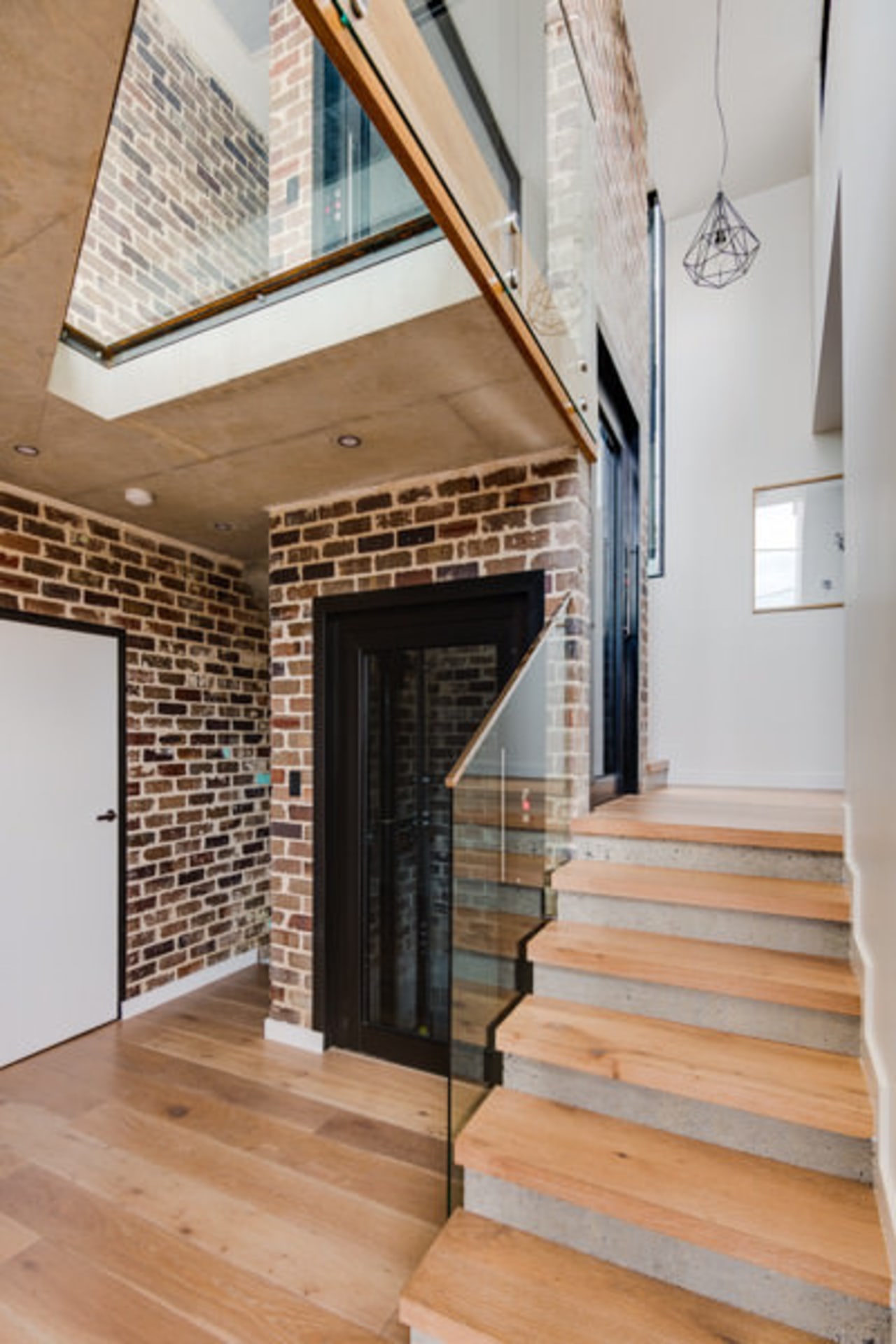 Recycled brick means the home has a touch architecture, brick, ceiling, daylighting, floor, flooring, handrail, hardwood, home, house, interior design, loft, real estate, stairs, wall, wood, wood flooring, gray