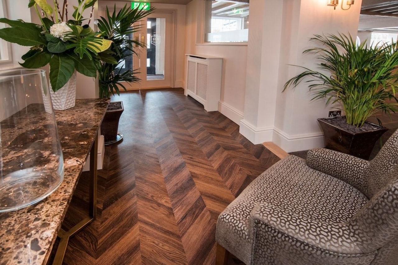 Herringbone patterns can give homes and commercial spaces floor, flooring, hardwood, home, interior design, laminate flooring, living room, real estate, tile, wood, wood flooring, brown, gray