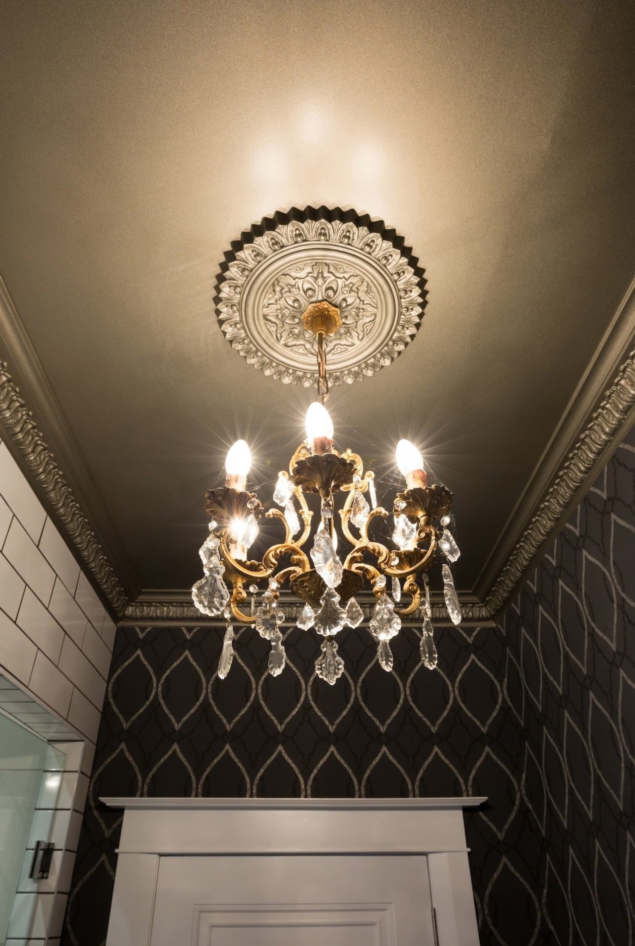 Chandelier and patterned wallpaper in powder room designed ceiling, chandelier, decor, light, light fixture, lighting, wall, black, brown