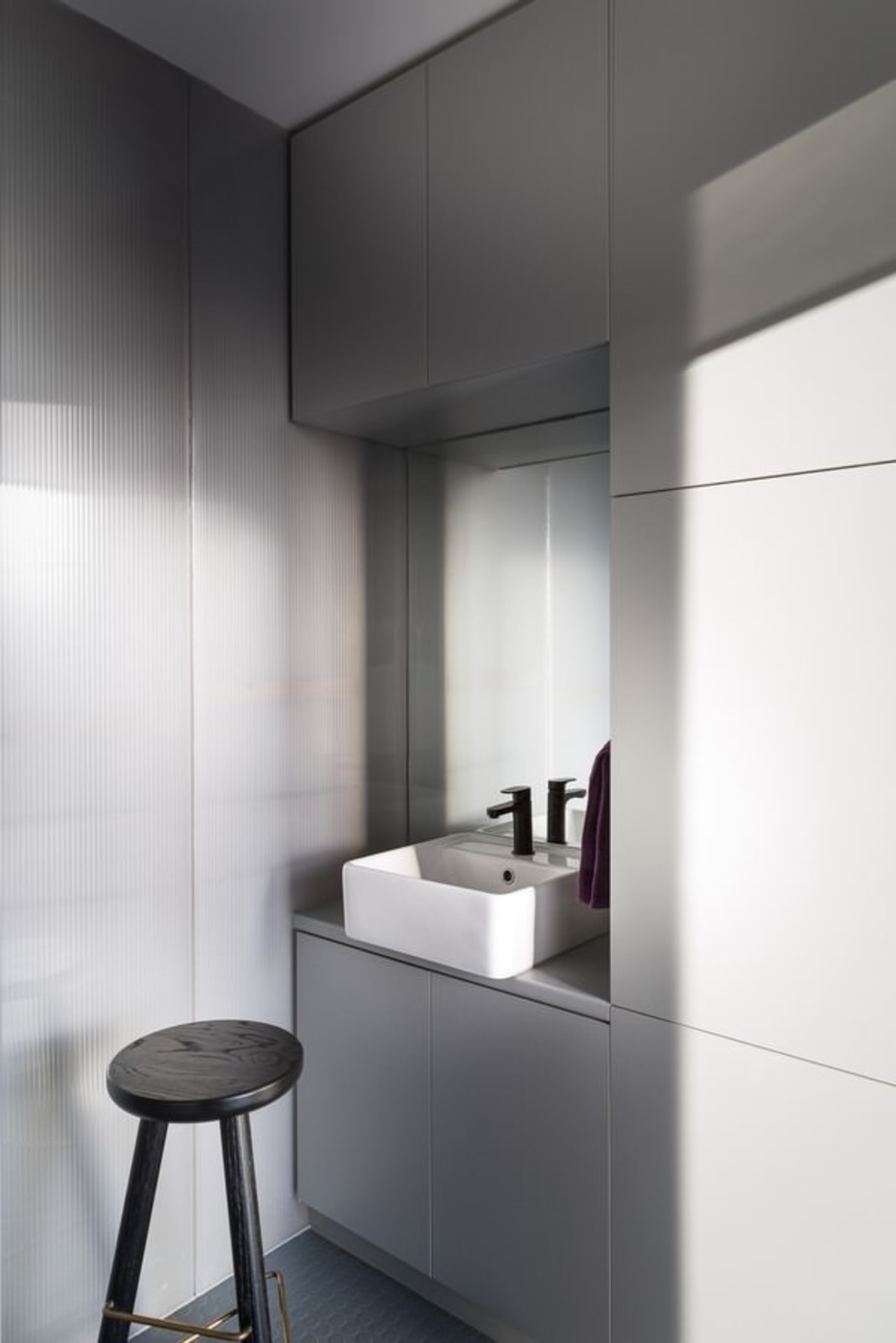 This tiny bathroom is distinctly modern and features floor, interior design, product design, tap, white, gray