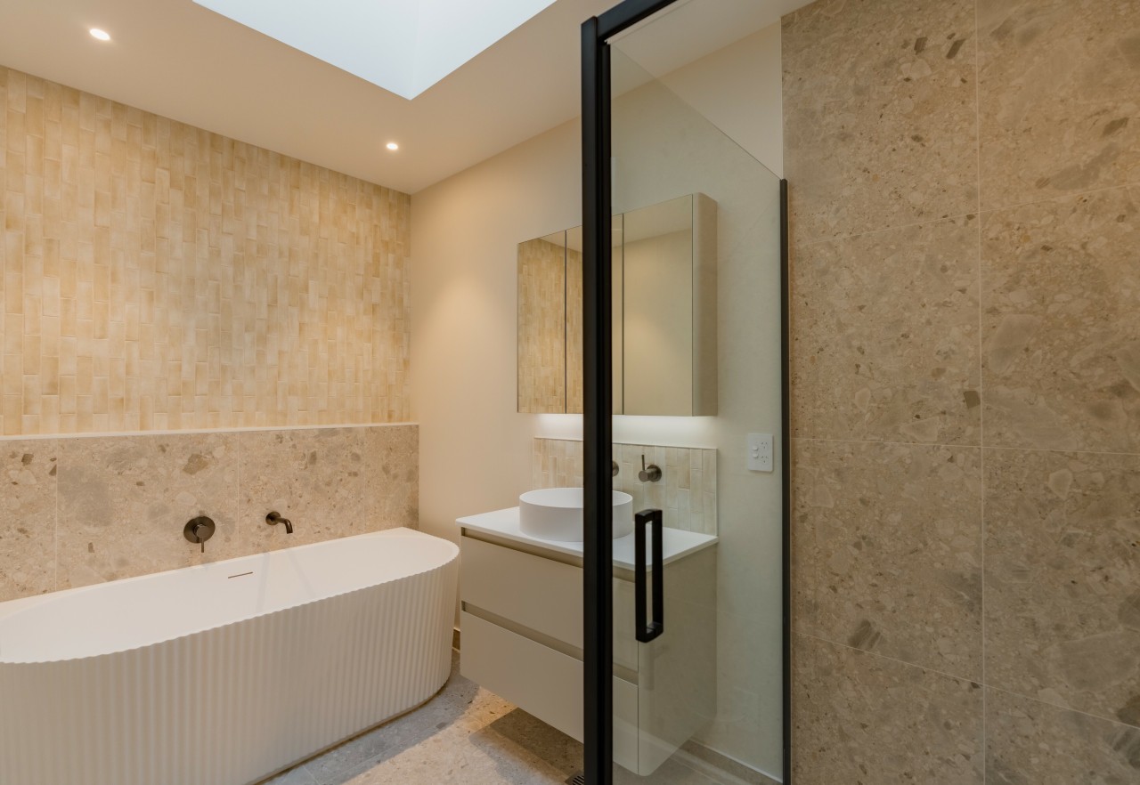 Soft stone-look tiles, warm neutrals, and a matte 