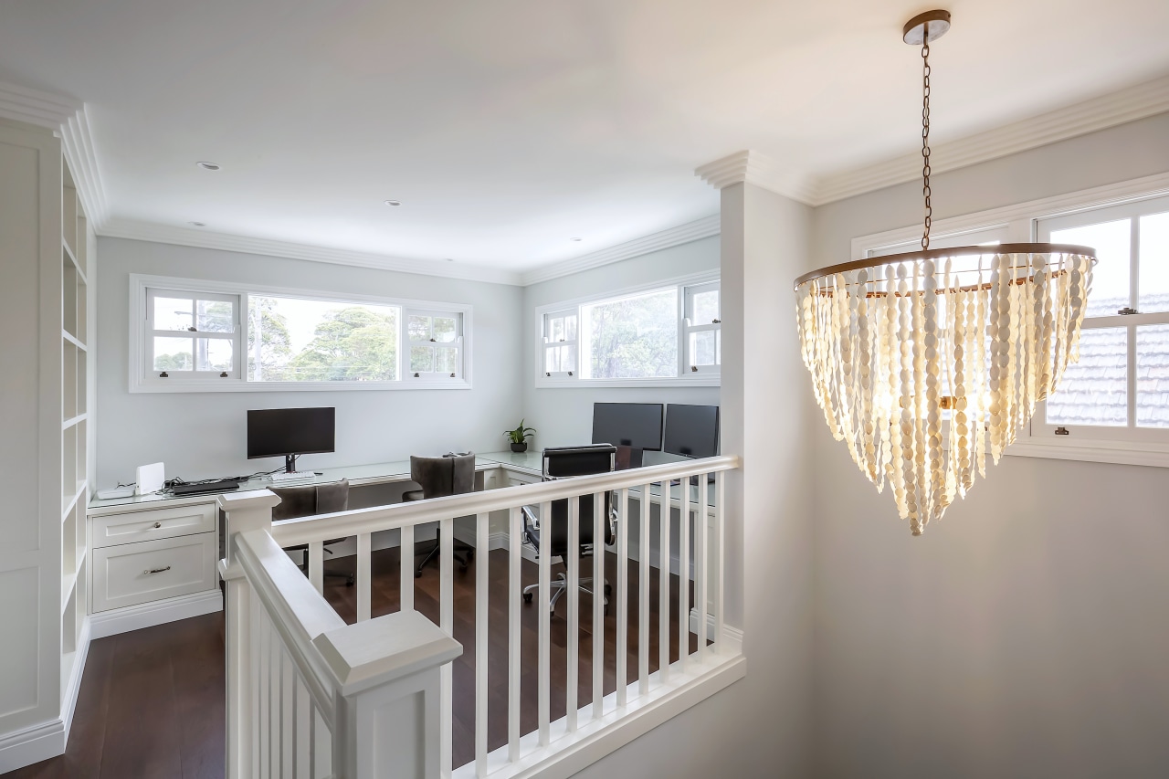 A gracious chandelier accentuates the crafted upstairs-downstairs connection. 