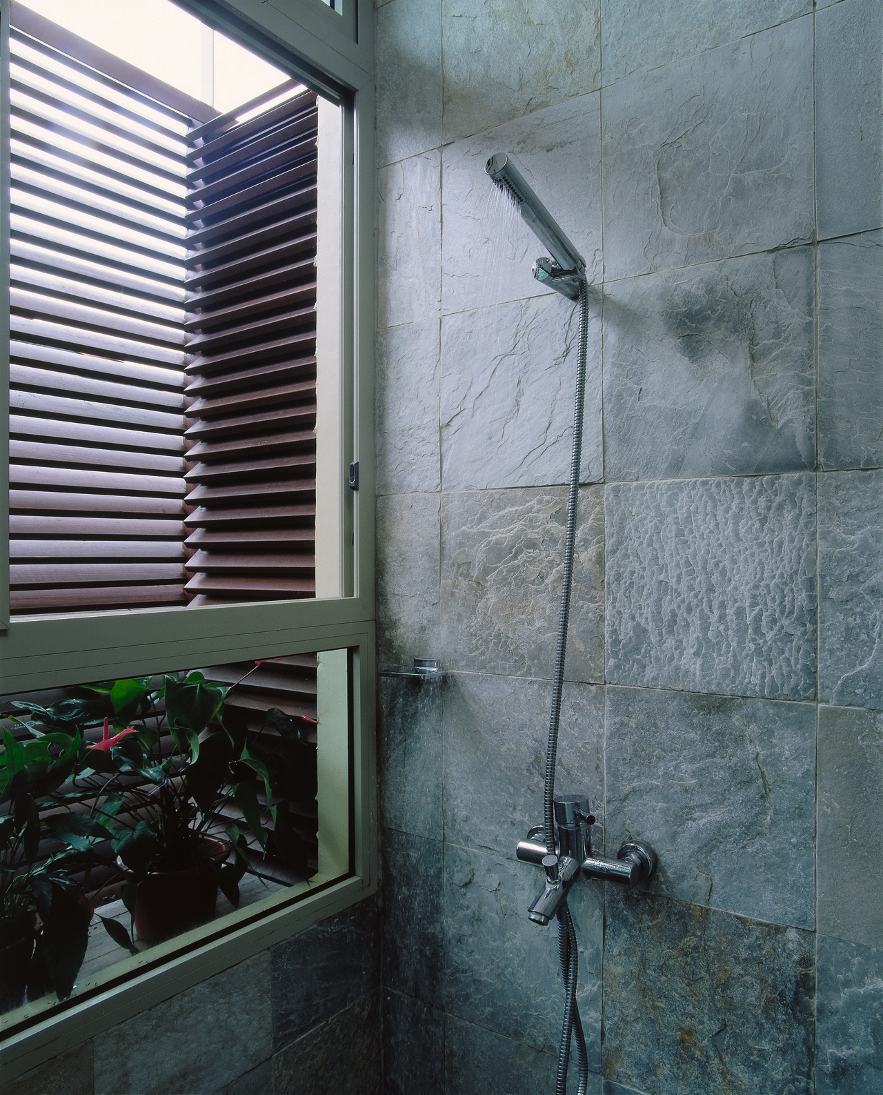 The detail of a shower with stone wall architecture, glass, house, plumbing fixture, wall, window, gray, black