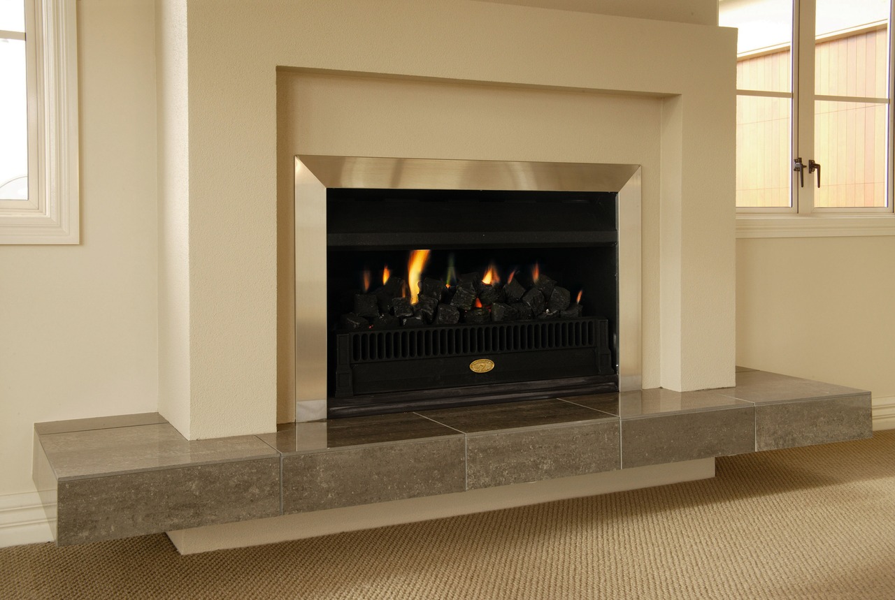 Indoor fireplace with cream and aluminium surround, and fireplace, hearth, heat, wood burning stove, orange, brown