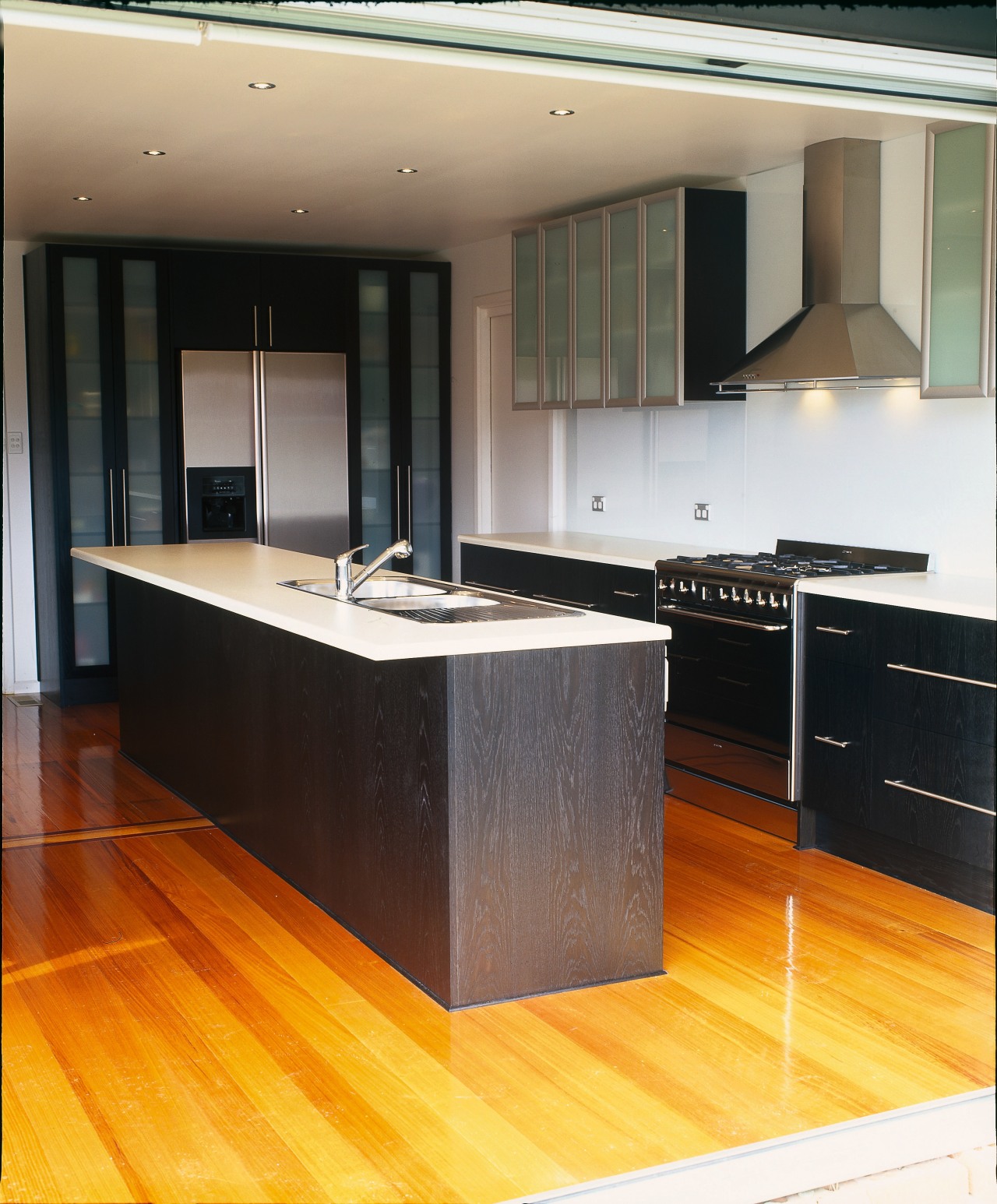 Kitchen with dark grey toned cabinetry, with glass cabinetry, countertop, cuisine classique, floor, flooring, hardwood, interior design, kitchen, laminate flooring, wood, wood flooring, black