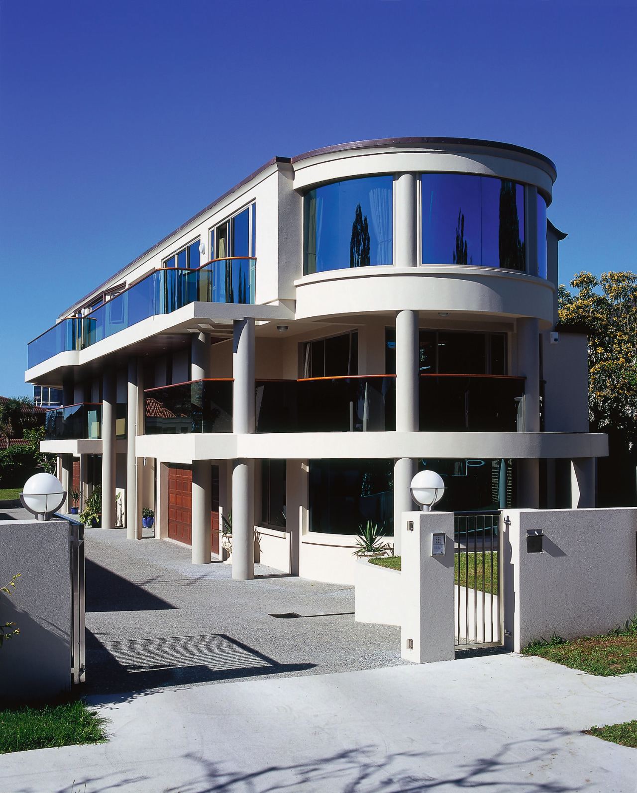 A view of this contemporary home with curved apartment, architecture, building, commercial building, condominium, corporate headquarters, elevation, facade, home, house, mixed use, property, real estate, residential area, blue