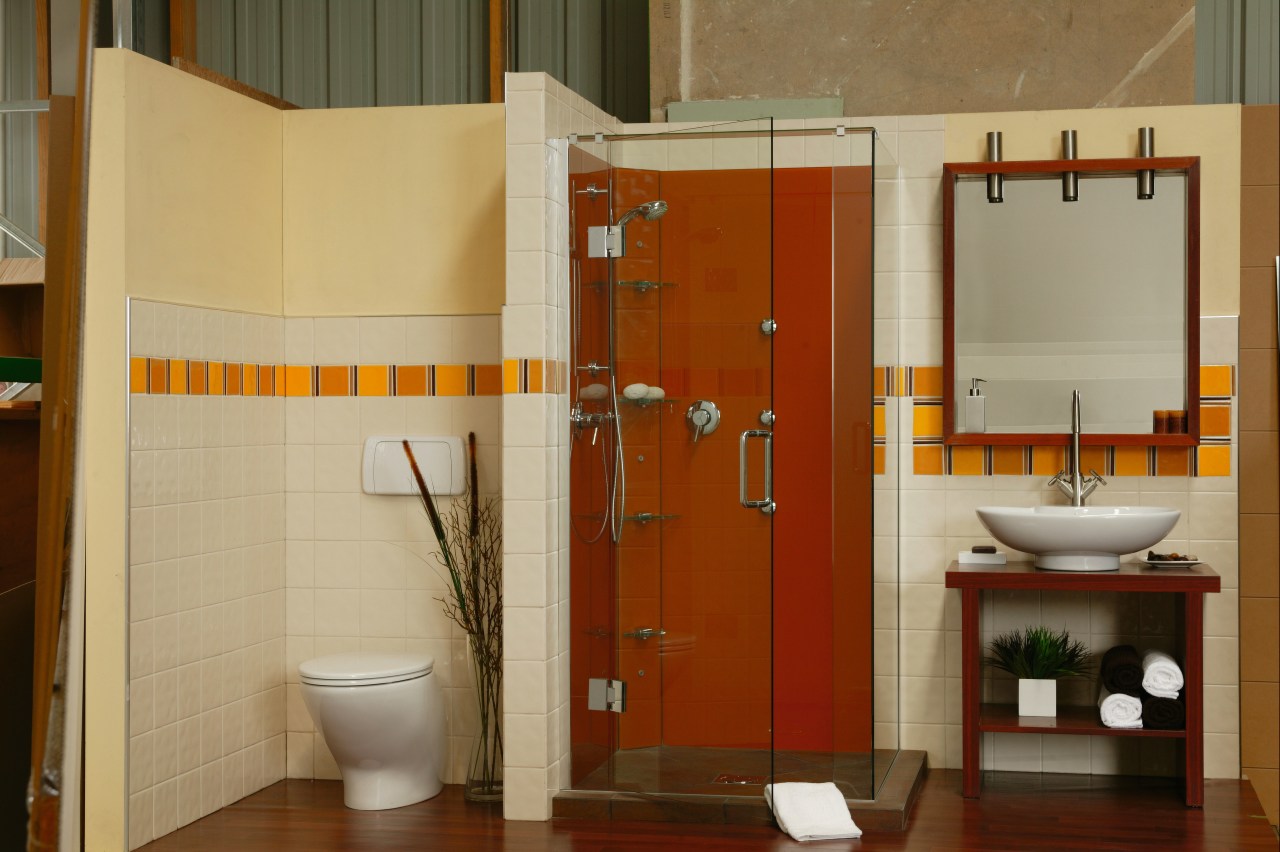 A bathroom featuring an orange coloured glass shower. bathroom, bathroom accessory, floor, interior design, plumbing fixture, room, toilet, brown, orange