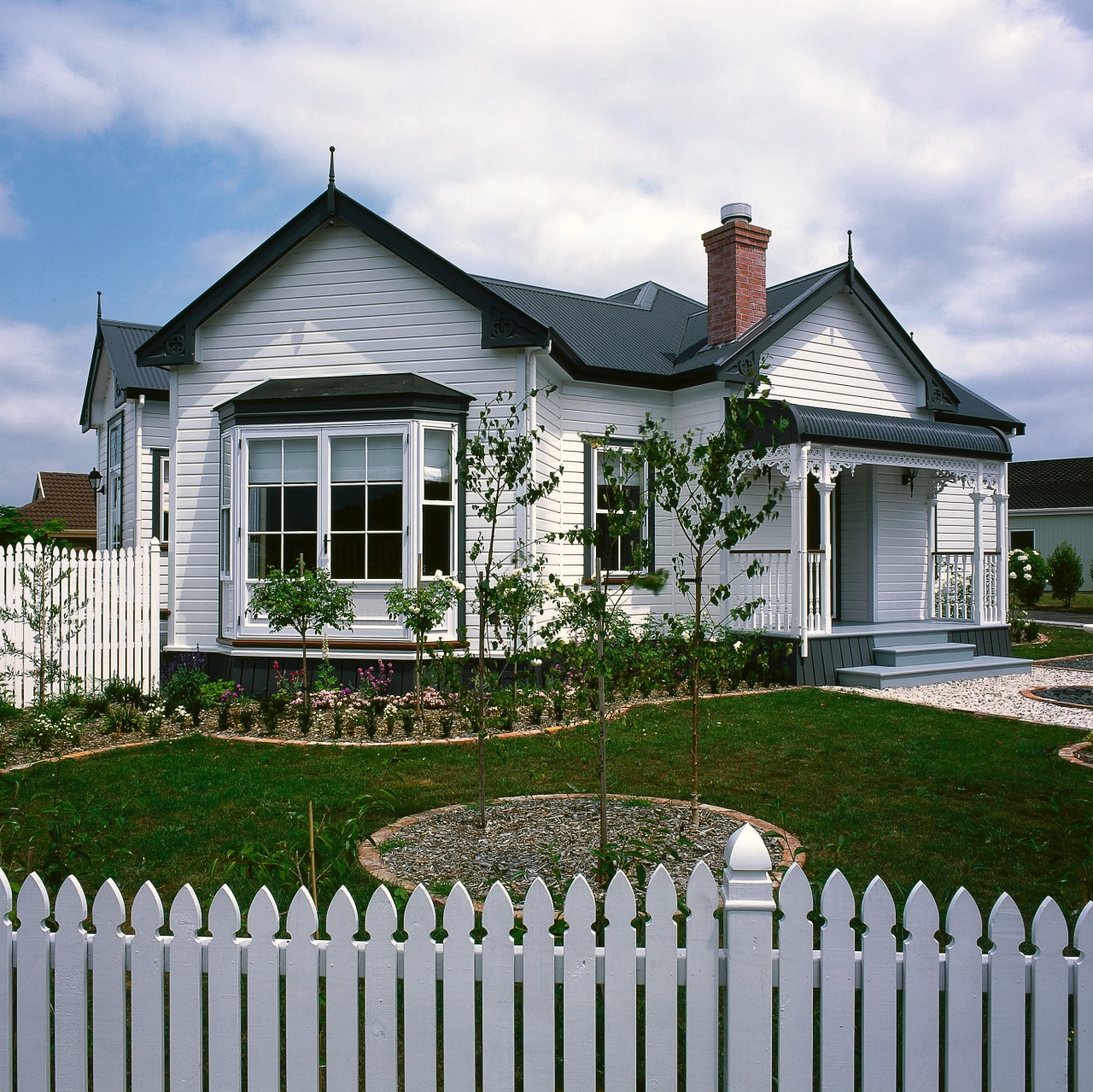 View of this classical hit cottage, elevation, estate, facade, farmhouse, fence, home, home fencing, house, landscaping, neighbourhood, outdoor structure, picket fence, property, real estate, residential area, siding, window, yard, gray