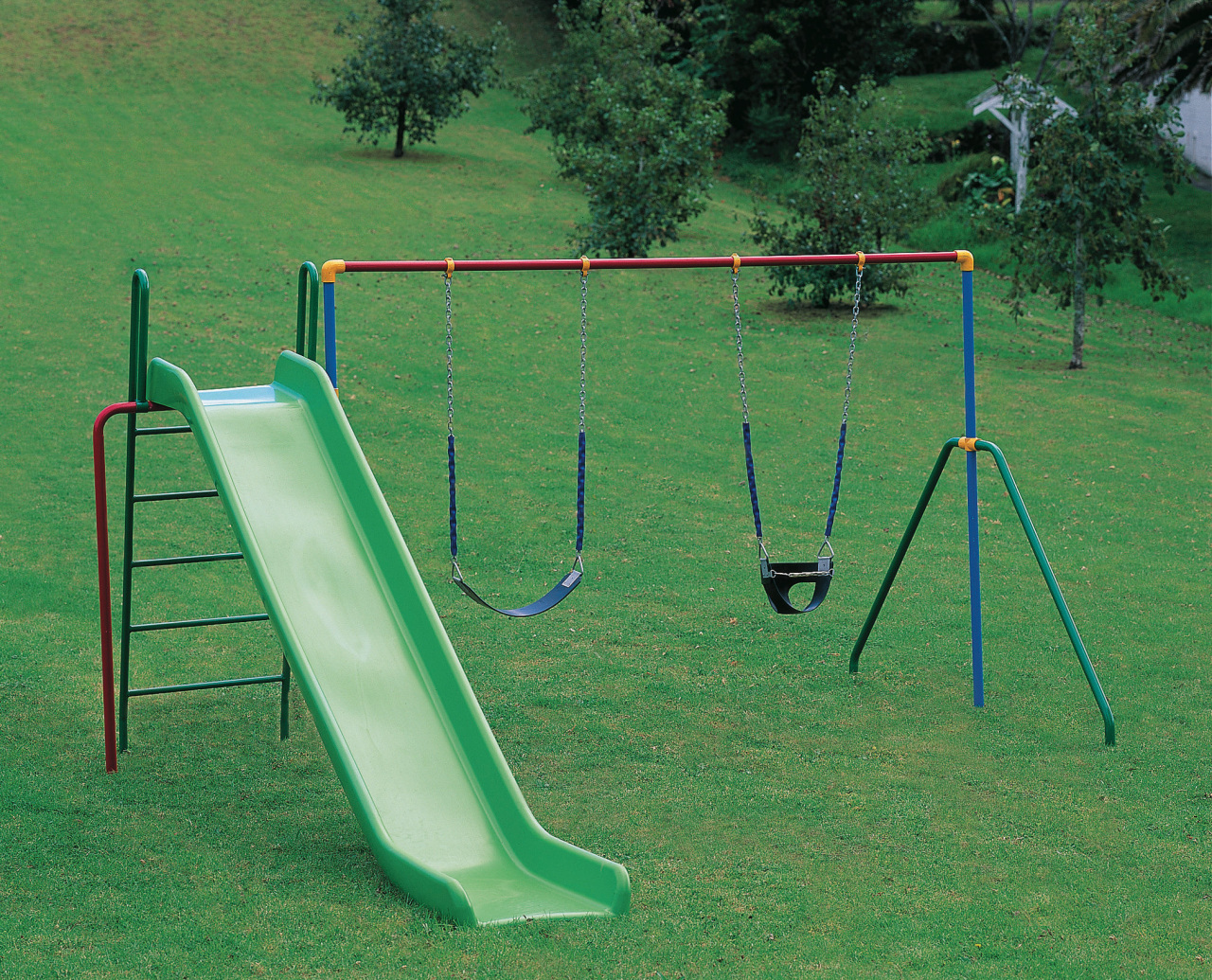 Outdoor play equipment with green slide, and two chute, grass, outdoor play equipment, playground, playground slide, public space, swing, green