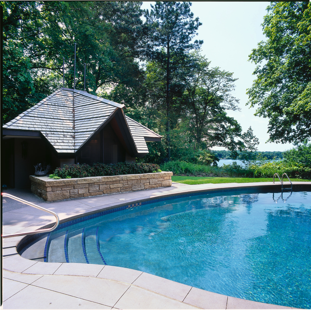 View of this outdoor living area backyard, estate, home, house, leisure, outdoor structure, plant, property, real estate, resort, swimming pool, tree, water, teal, white