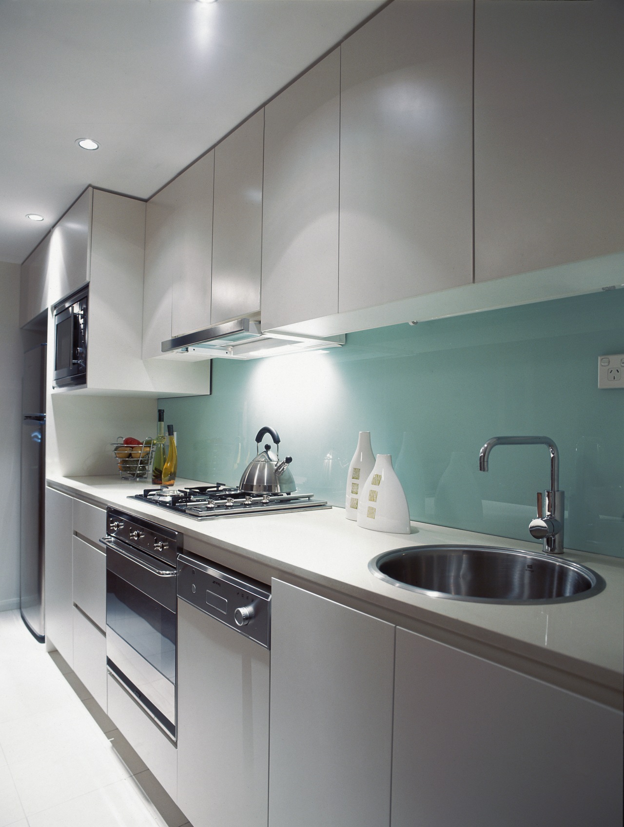 Kitchen along wall with light coloured cabinetry, stainless cabinetry, countertop, interior design, kitchen, product design, sink, under cabinet lighting, gray