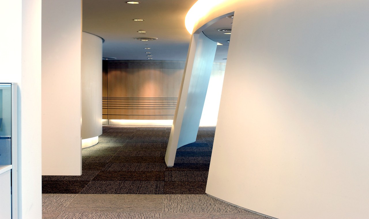 View of walkway through office boardered by sloping architecture, ceiling, daylighting, floor, flooring, interior design, property, real estate, white