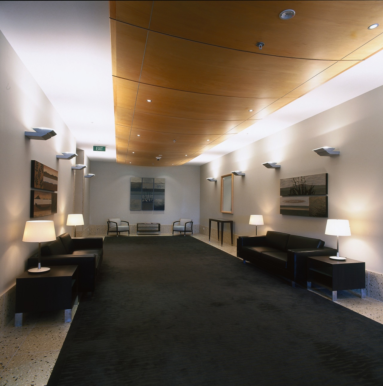 The lobby of this apartment building has curved architecture, ceiling, daylighting, floor, flooring, interior design, lobby, black, gray