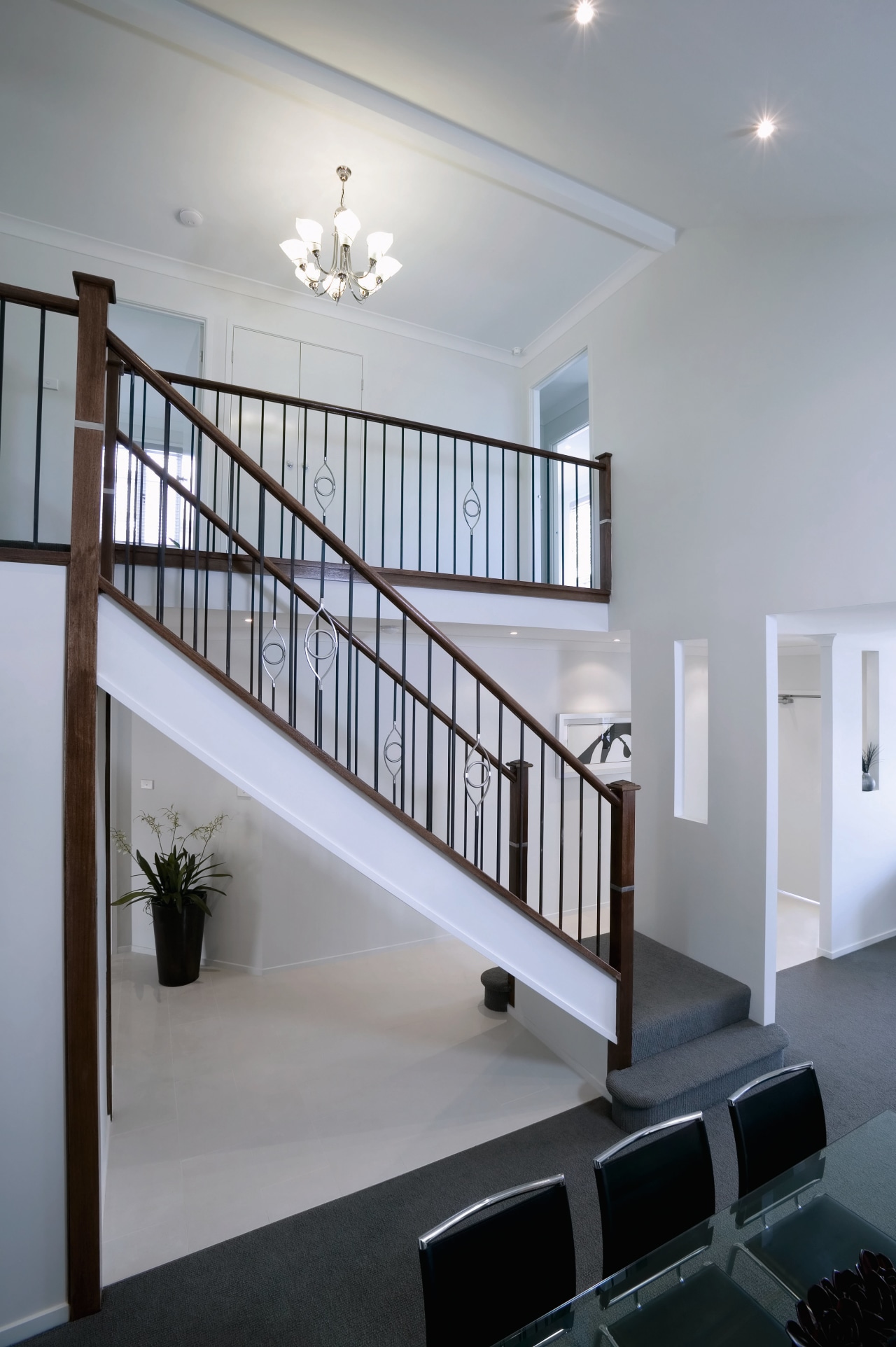 Open stairwell with ornate balustrades, white walls and architecture, baluster, ceiling, daylighting, estate, handrail, home, house, interior design, real estate, stairs, wall, gray